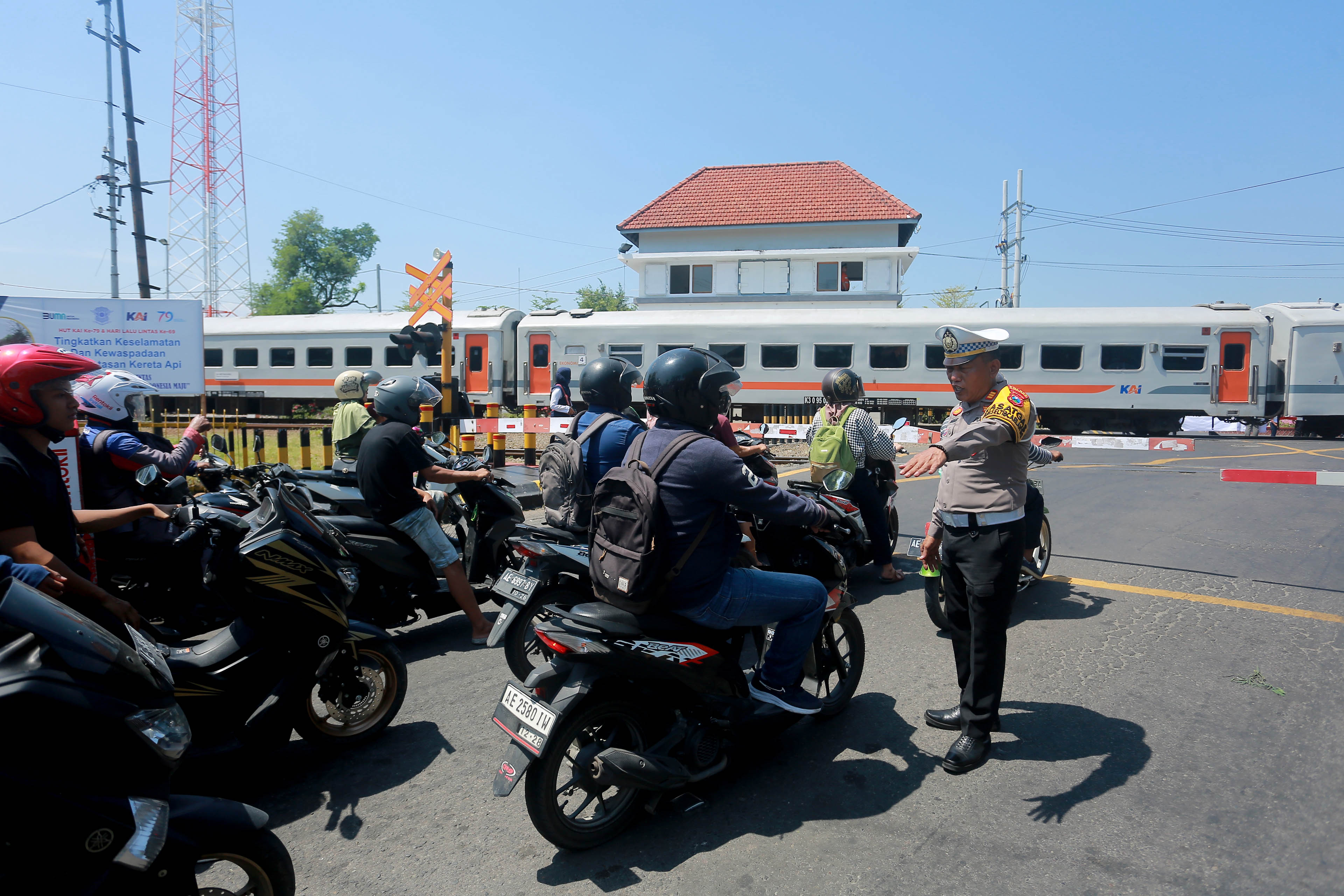 BERTUGAS: Satlantas Polres Madiun Kota menertibkan arus lalu lintas di kawasan perlintasan KA Jalan Pahlawan-Yos Sudarso, Kamis (19/9). (BAGAS BIMANTARA/RADAR MADIUN)