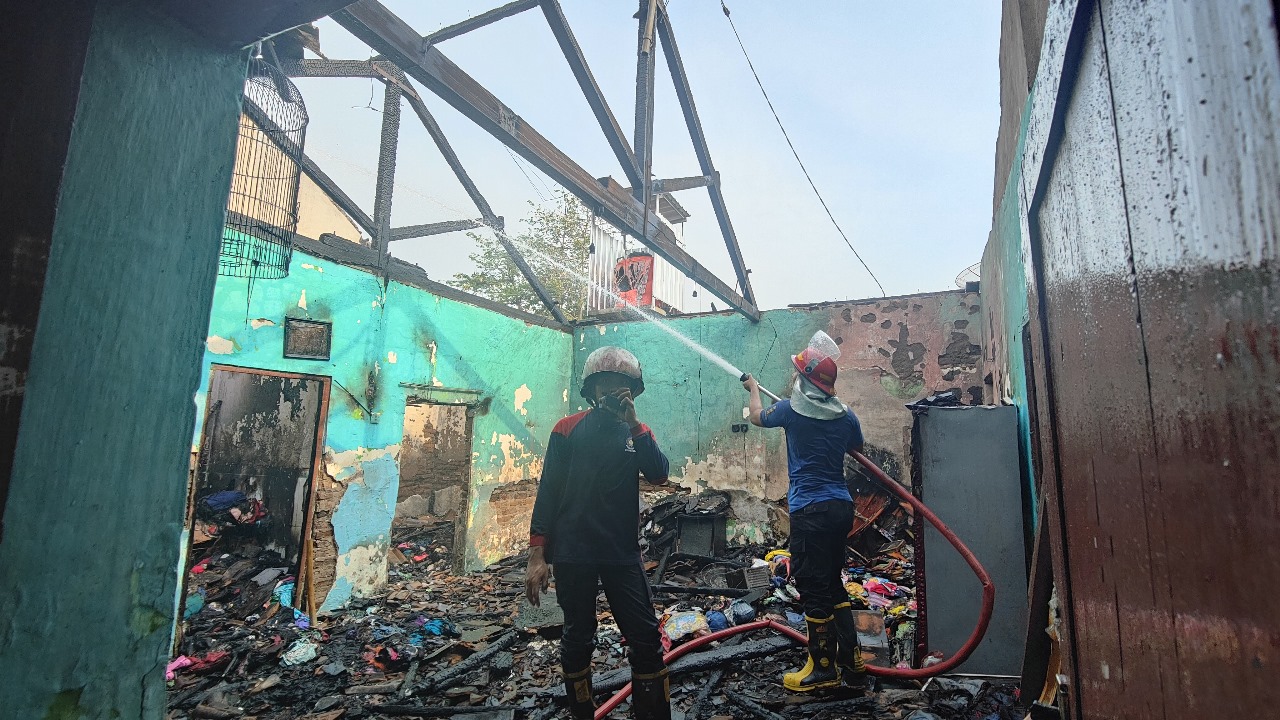 LUDES: Petugas damkar berusaha memadamkan api di rumah Darti, warga Jomblang, Takeran, Magetan, Selasa (24/9) pagi.