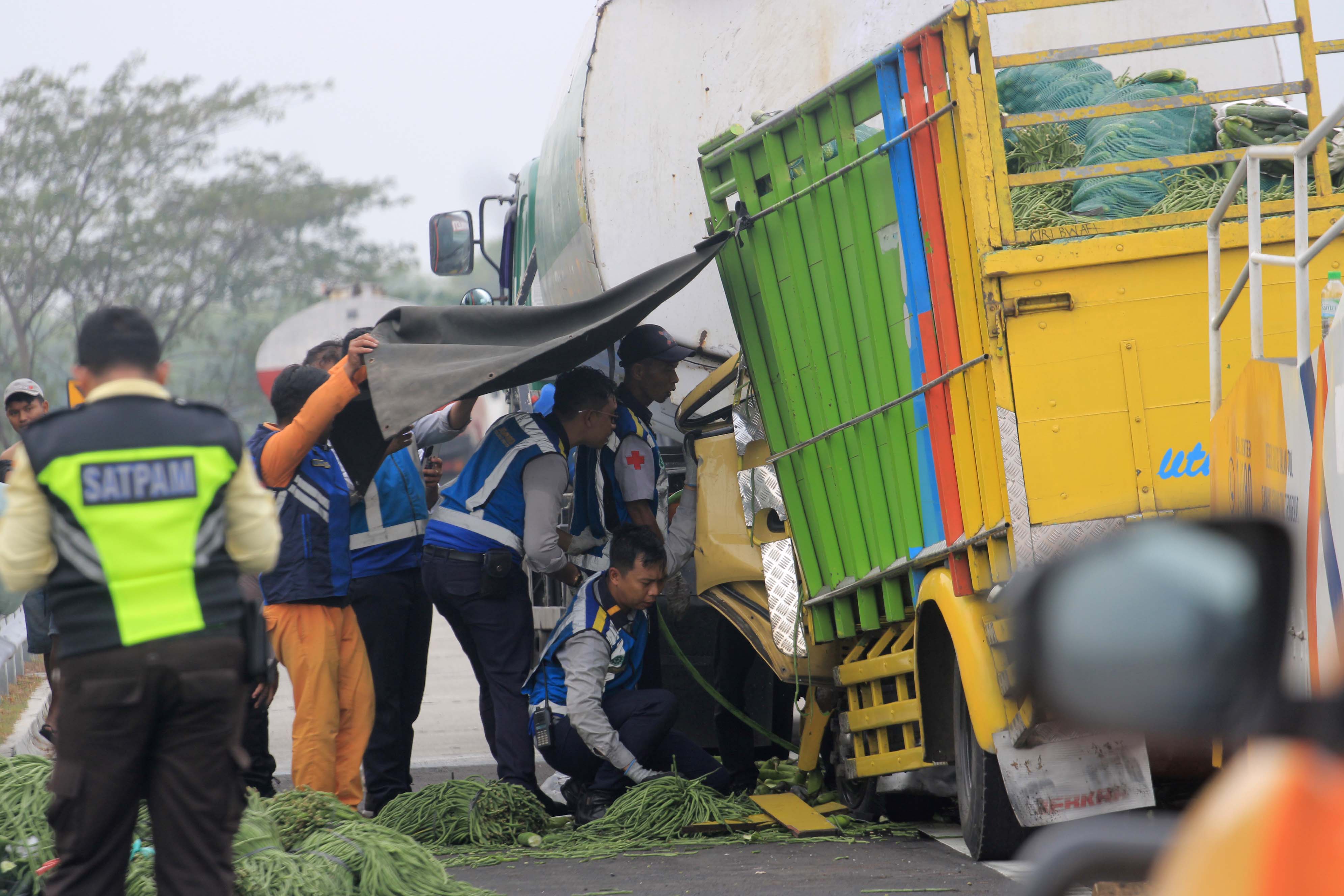 EVAKUASI: Petugas berupaya mengevakuasi sopir dan kernet truk yang mengalami laka lantas di KM 594 Tol Surabaya-Ngawi, tepatnya di wilayah Kartoharjo, Magetan, Kamis (26/9) sore.