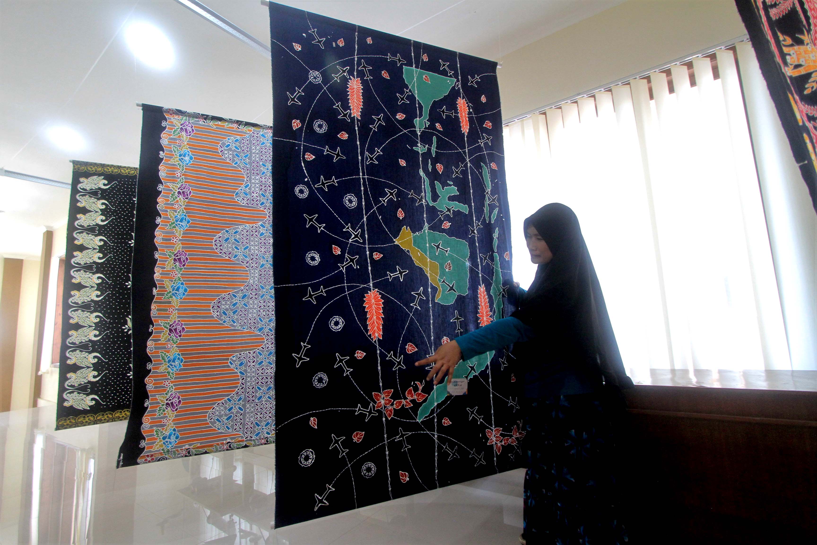 PAMERAN: Perajin memamerkan batik pesawat di Rumah Promosi Magetan, Selasa (1/10).