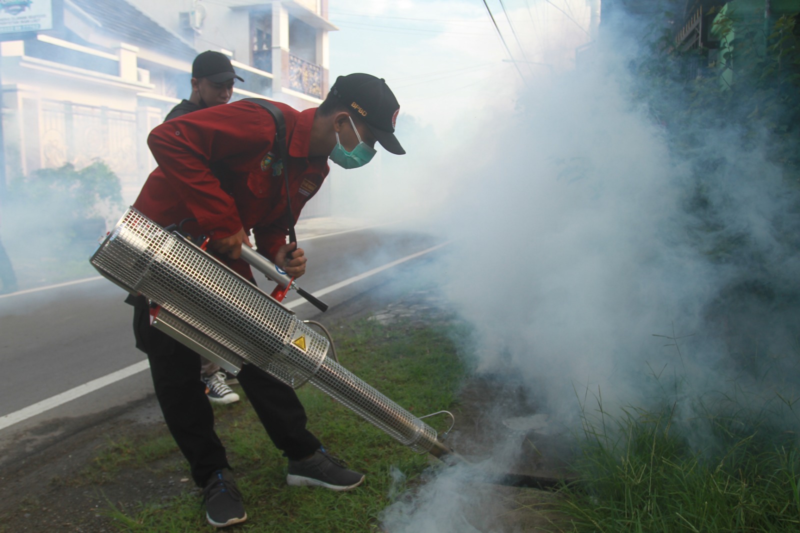 BERANTAS NYAMUK DEWASA: Seorang petugas mem-fogging salah satu kawasan di Kota Madiun. (BAGAS BIMANTARA/JAWA POS RADAR MADIUN)