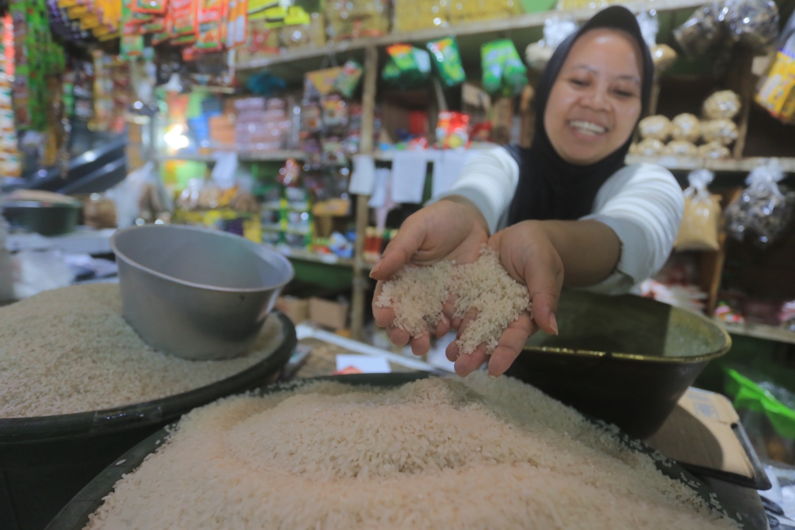 BAHAN PANGAN: Seorang penjual beras di salah satu pasar di Kota Madiun menunjukkan barang dagangannya. (BAGAS BIMANTARA/JAWA POS RADAR MADIUN)