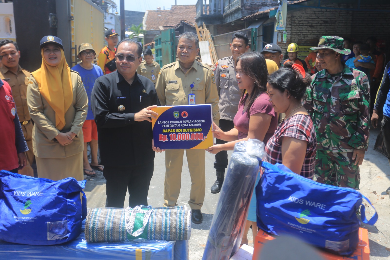Pj Wali Kota Madiun Eddy Supriyanto menyerahkan bantuan kepada korban rumah roboh, Senin (21/10). (BAGAS BIMANTARA/RADAR MADIUN)