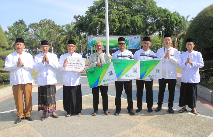 TERLINDUNGI: Kepala BPJS Ketenagakerjaan Cabang Madiun Anwar Hidayat (dua dari kanan) dan perwakilan marbot, saat peringatan Hari Santri Nasional di Alun-alun Magetan, Selasa (22/10).