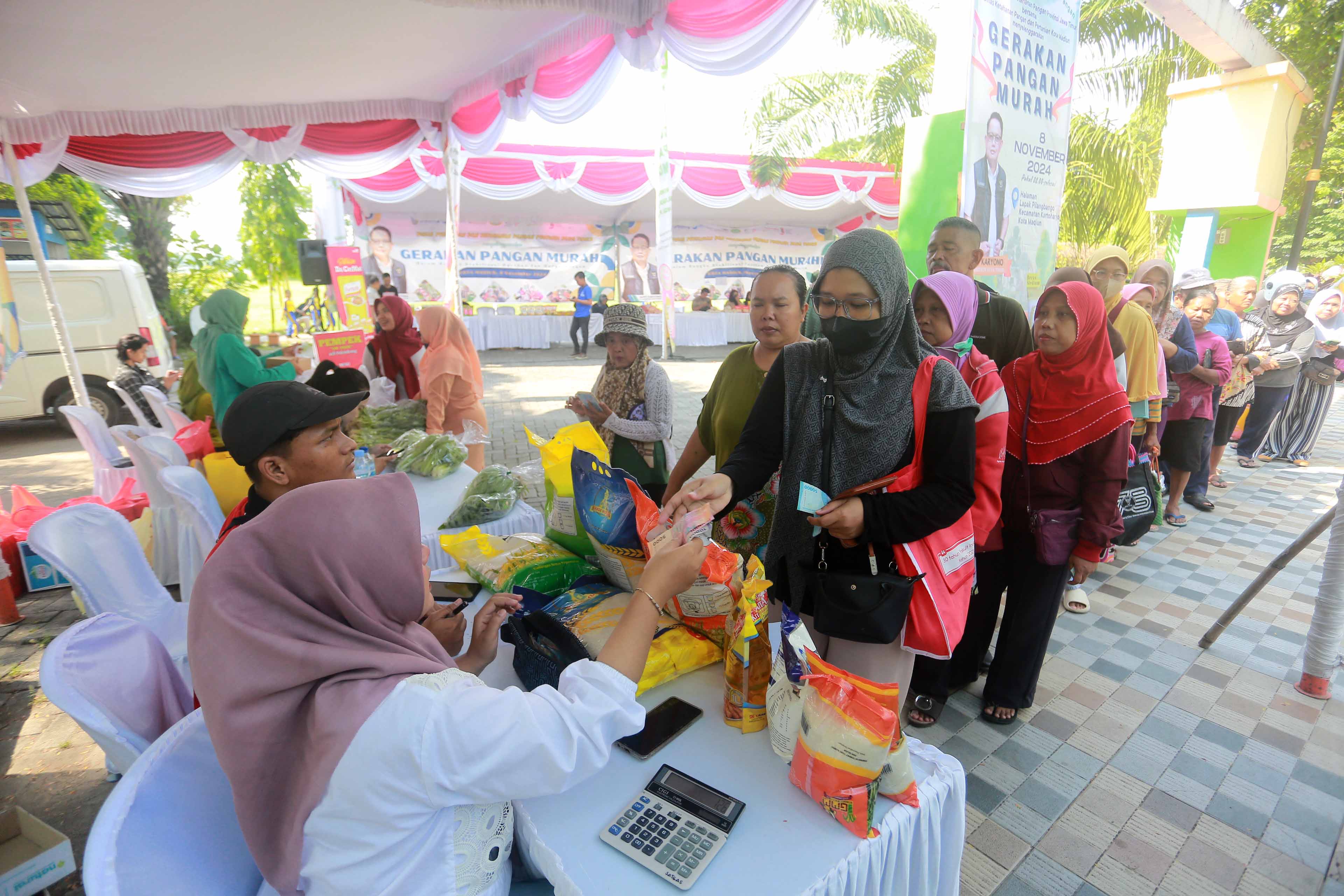 MURAH MERIAH: Warga mengantre demi mendapatkan bahan pokok dengan harga terjangkau dalam Gerakan Pangan Murah (GPM) di Lapak Pilangbango kemarin (8/11). (BAGAS BIMANTARA/RADAR MADIUN)