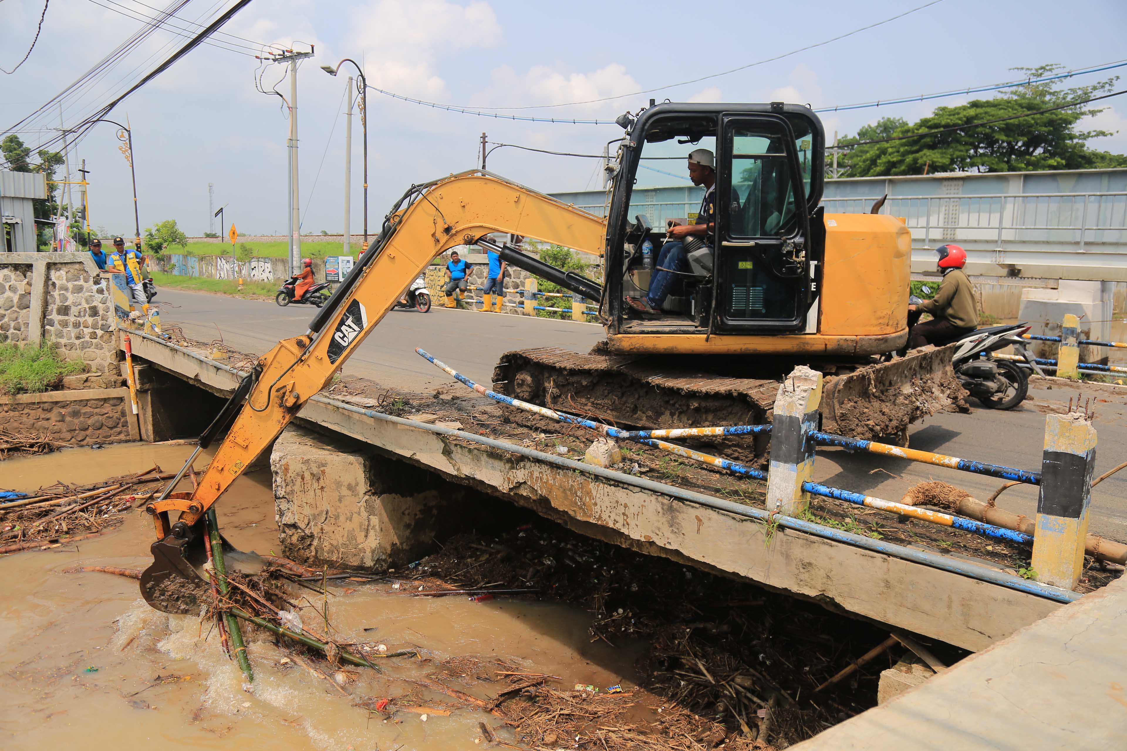 MITIGASI: Petugas BPBD Kota Madiun membersihkan sampah bambrongan yang menyumbat aliran Kali Piring persisnya di bawah Jembatan Bok Malang, Jumat 22 November 2024.