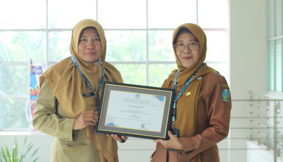 MONCER: Kepala SMKN 1 Jiwan Murtiru bersama Titik Roesmiati menunjukkan piagam penghargaan peringkat 5 GTK Dedikatif dari BBGP Jatim.