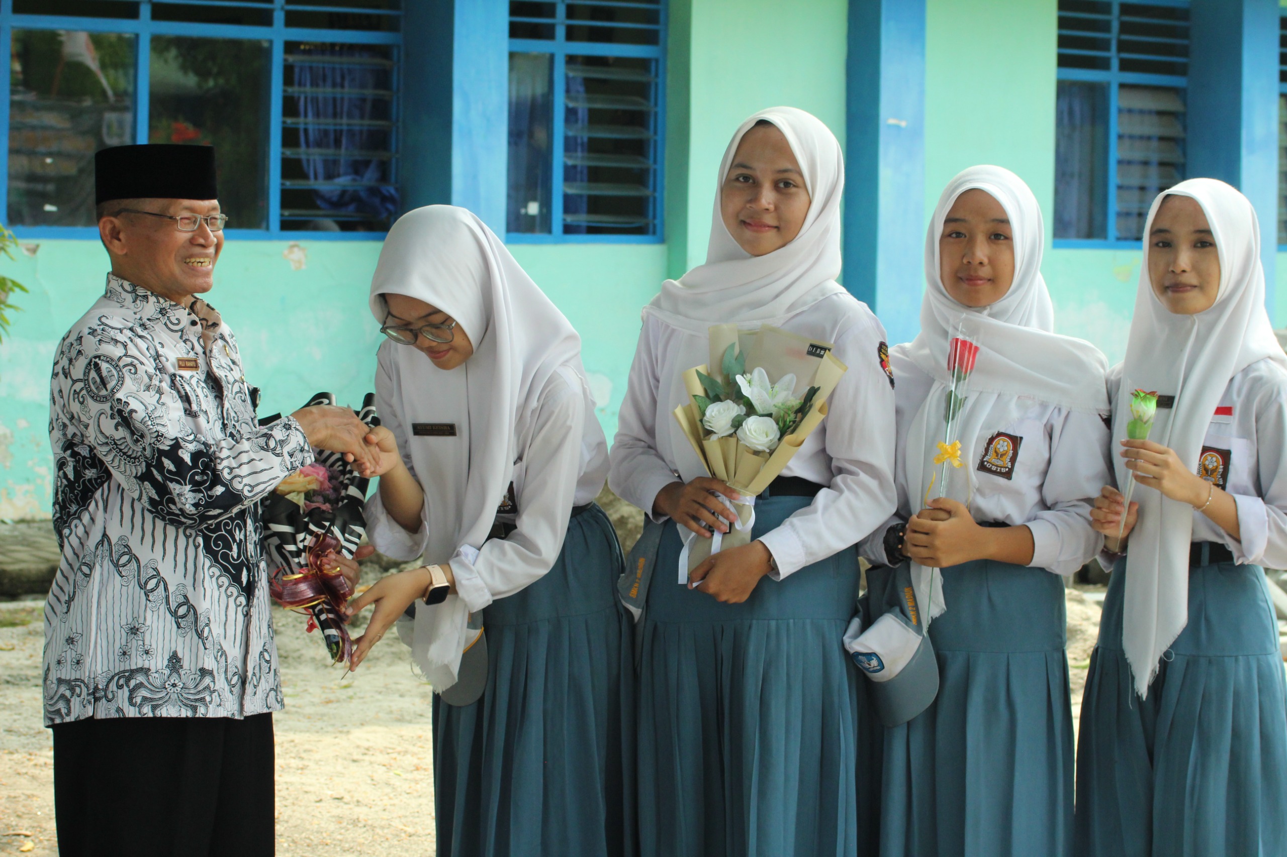 HORMAT: Siswa-siswi secara bergantian memberikan bunga kepada kepala SMKN 2 Madiun dan para guru.