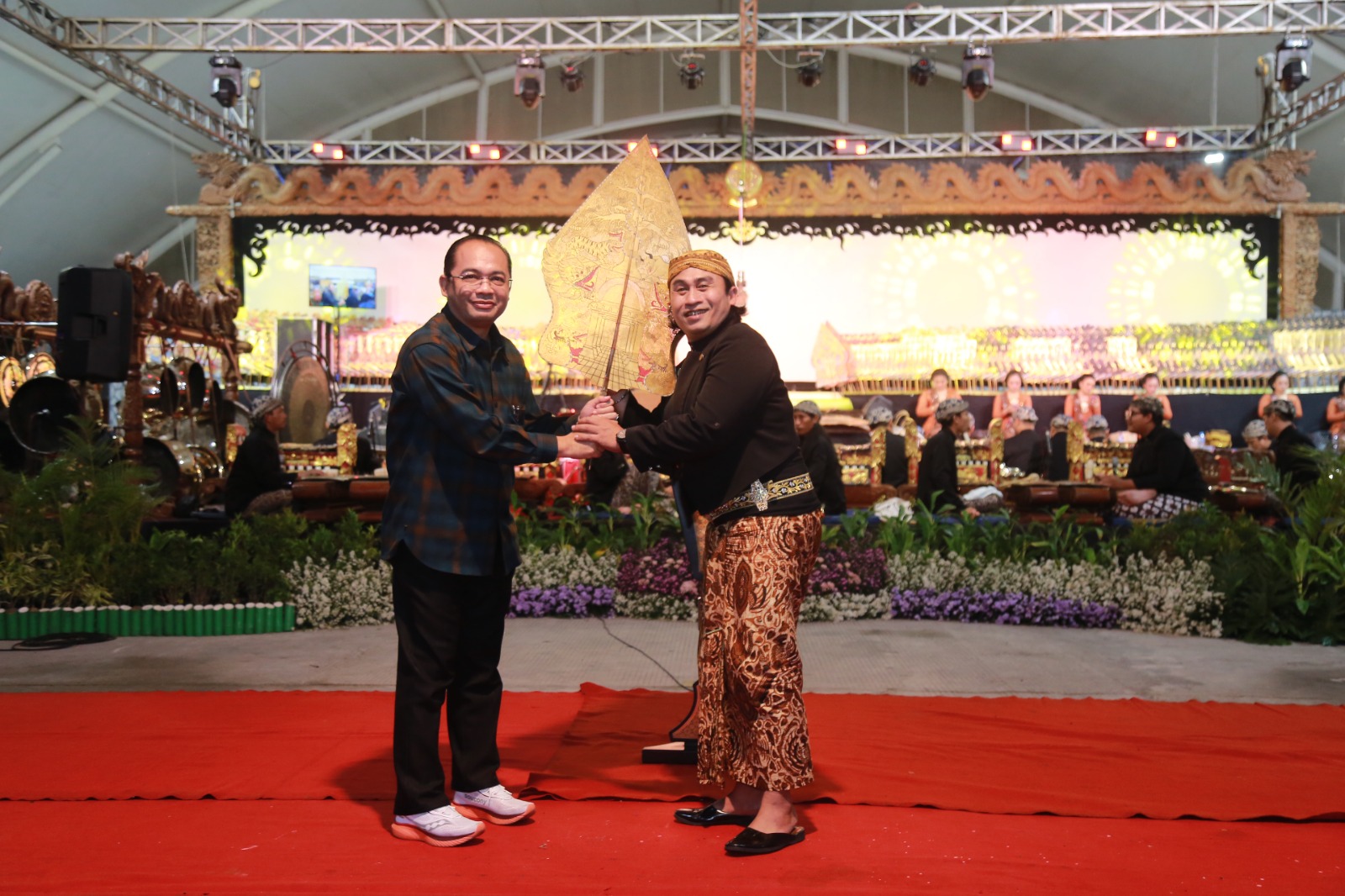 BUDAYA: Pj Wali Kota Madiun Eddy Supriyanto memberikan gunungan wayang kepada Dalang Ki Anom Dwijokangko sebagai dimulainya pagelaran wayang kulit di PBC, Sabtu (7/12). (BAGAS BIMANTARA/RADAR MADIUN)
