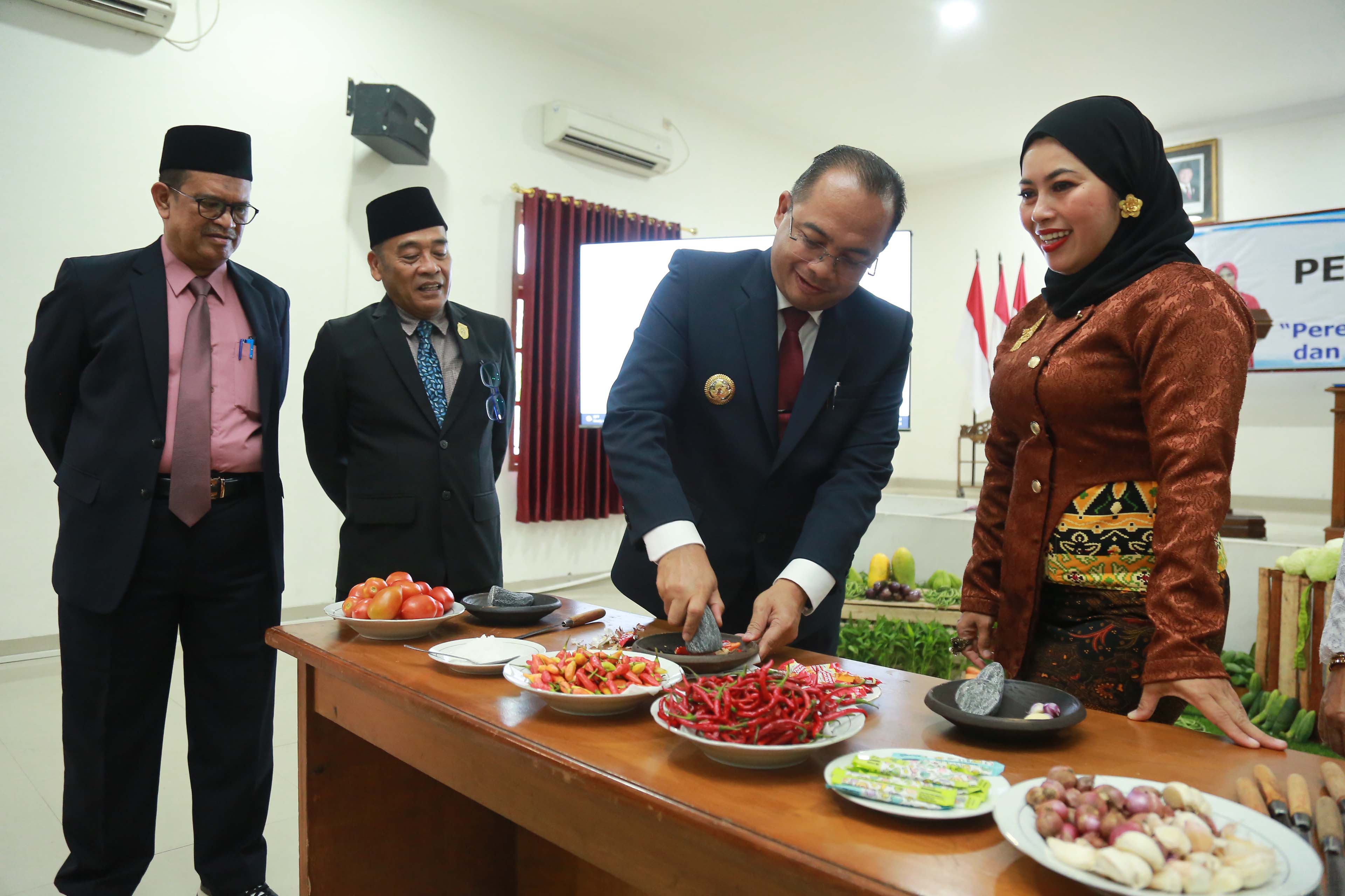 PERINGATAN HARI IBU: Pj. Wali Kota Madiun Eddy Supriyanto mengulek sambal di gedung diklat pemkot setempat kemarin (23/12). (BAGAS BIMANTARA/JAWA POS RADAR MADIUN)