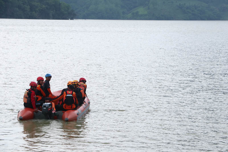 TERKENDALA CUACA: Basarnas Trenggalek dan BPBD Ponorogo dibantu relawan melakukan pencarian korban tenggelam di Waduk Bendo, Minggu (22/12).