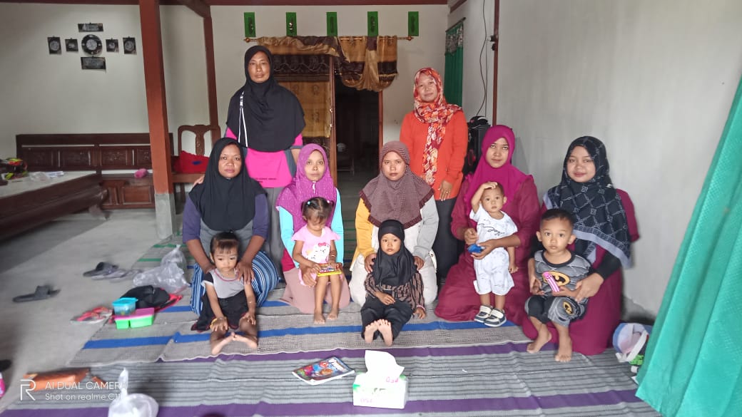 PENANGGULANGAN STUNTING: Sejumlah warga menerima bantuan makanan tambahan dari Kades dan Ketua PKK Desa Mojo.
