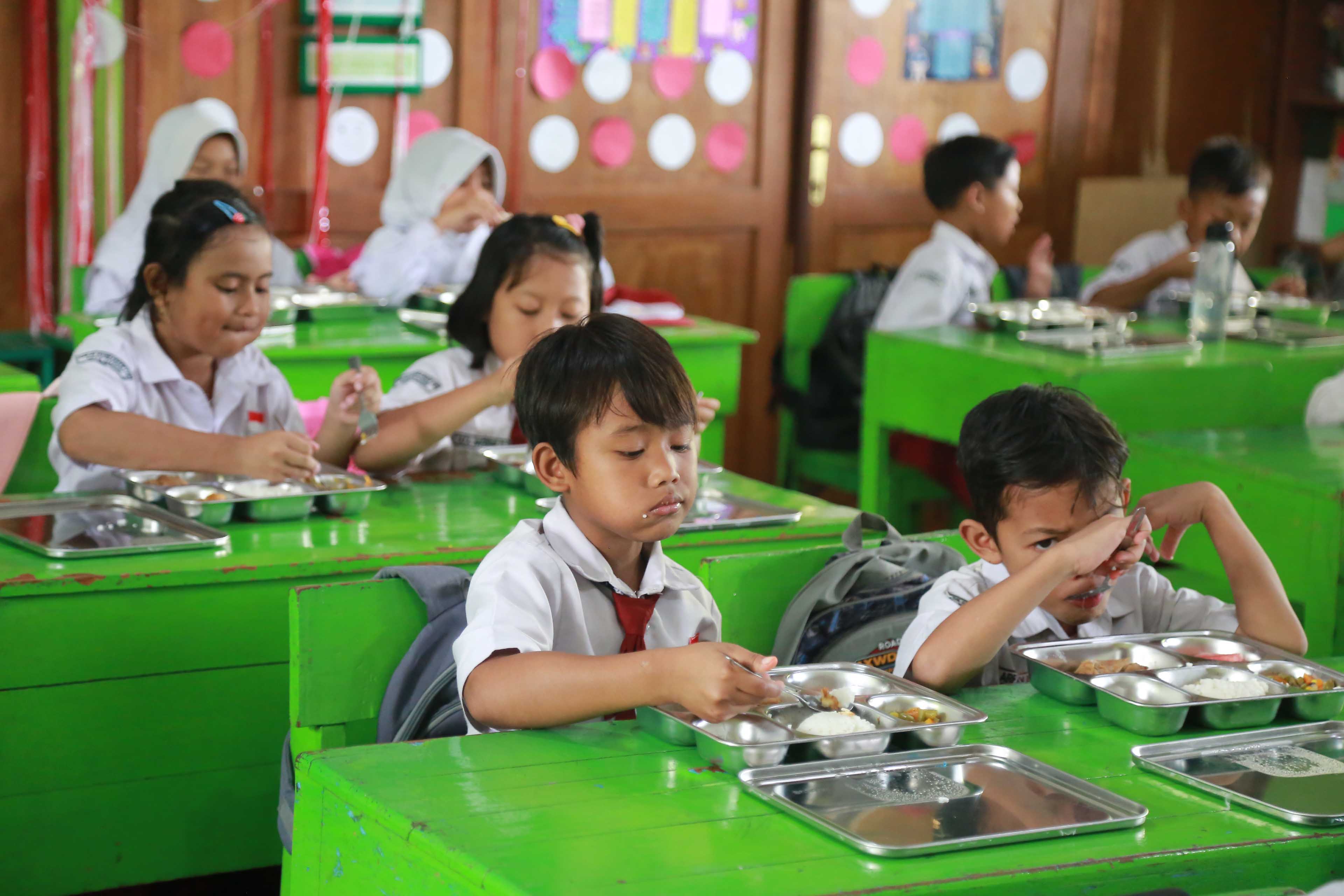 PETUGAS: mendistribusikan makan bergizi gratis di SDN 02 Nambangan Lor, kemarin 6 Januari 2024 siang.