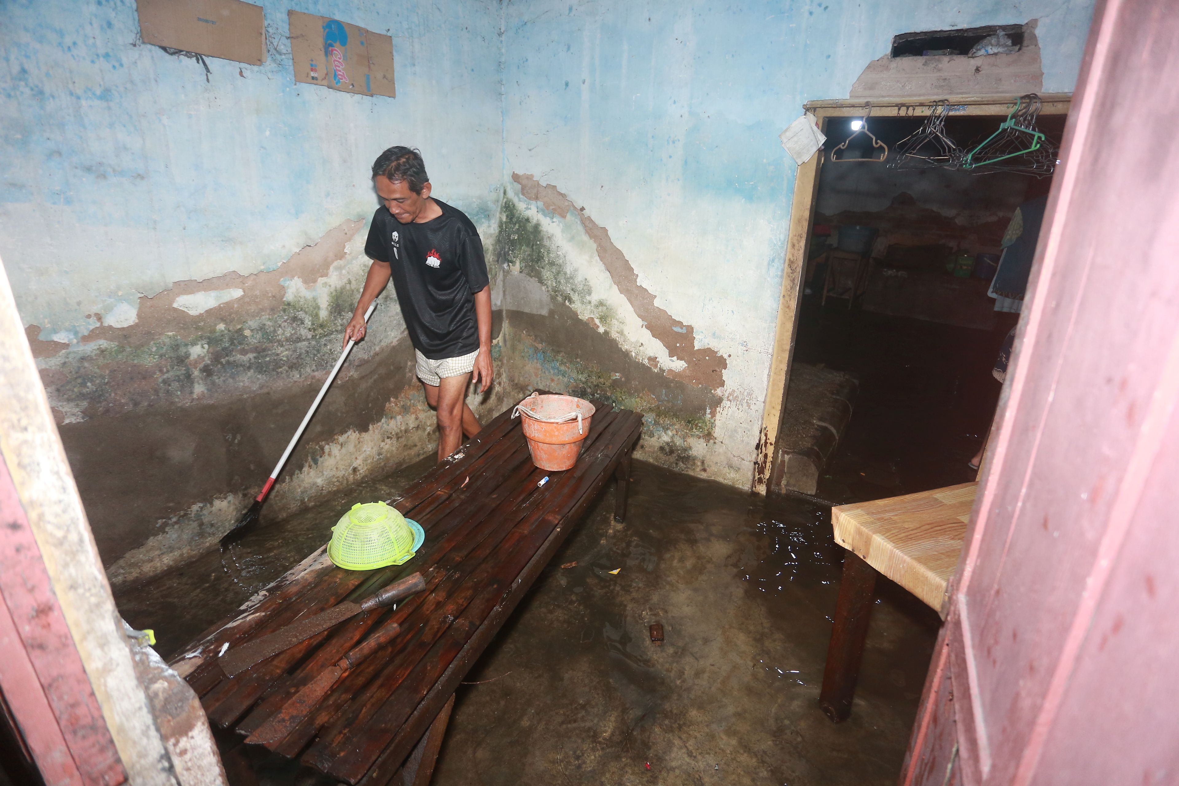 TERDAMPAK: Salah seorang warga Kota Madiun membersihkan rumah usai dilanda banjir beberapa waktu lalu.