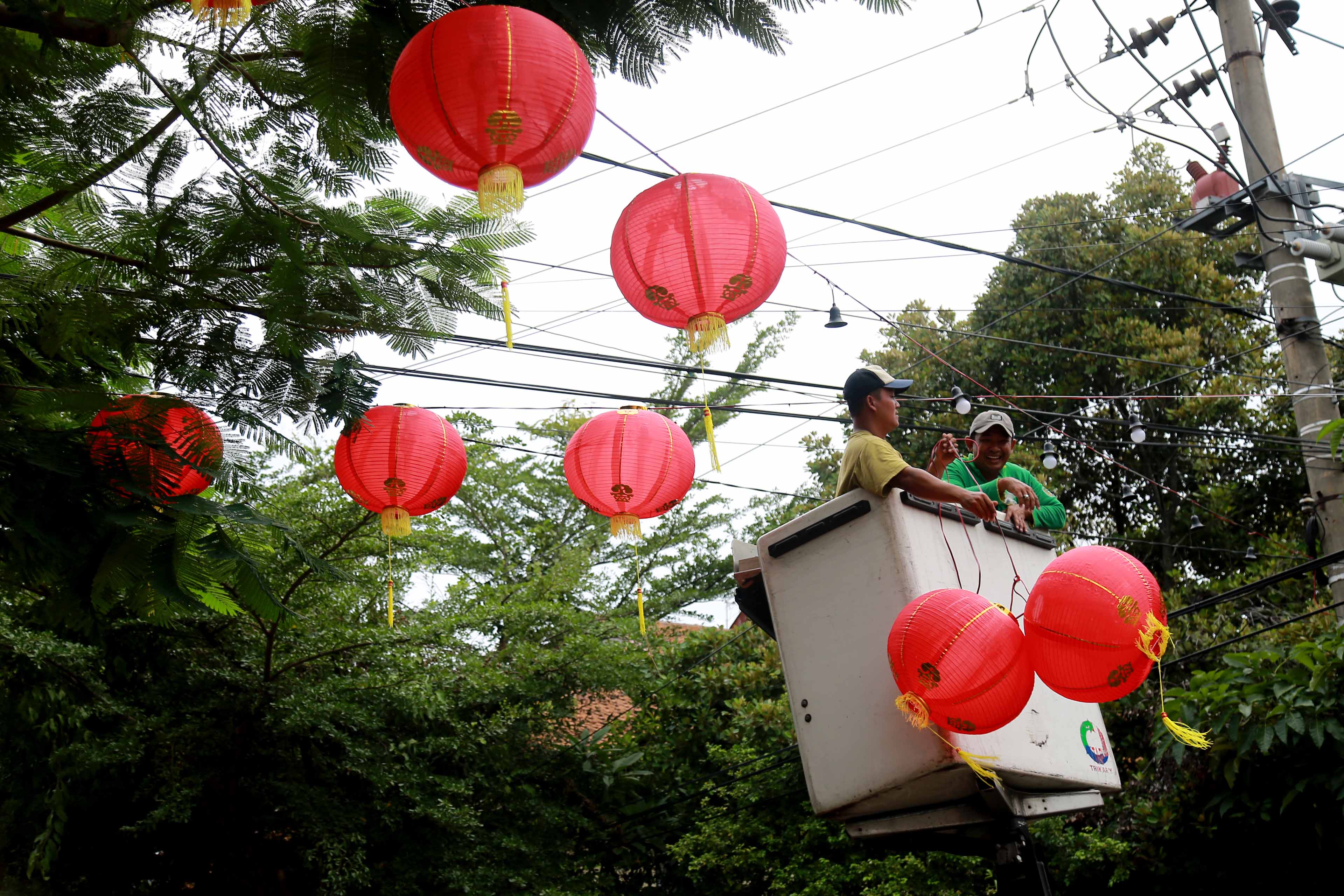 INSTALASI: Petugas dari disperkim memasang seratusan lampion atau lentera berwarna merah-emas di sepanjang Jalan Batanghari.