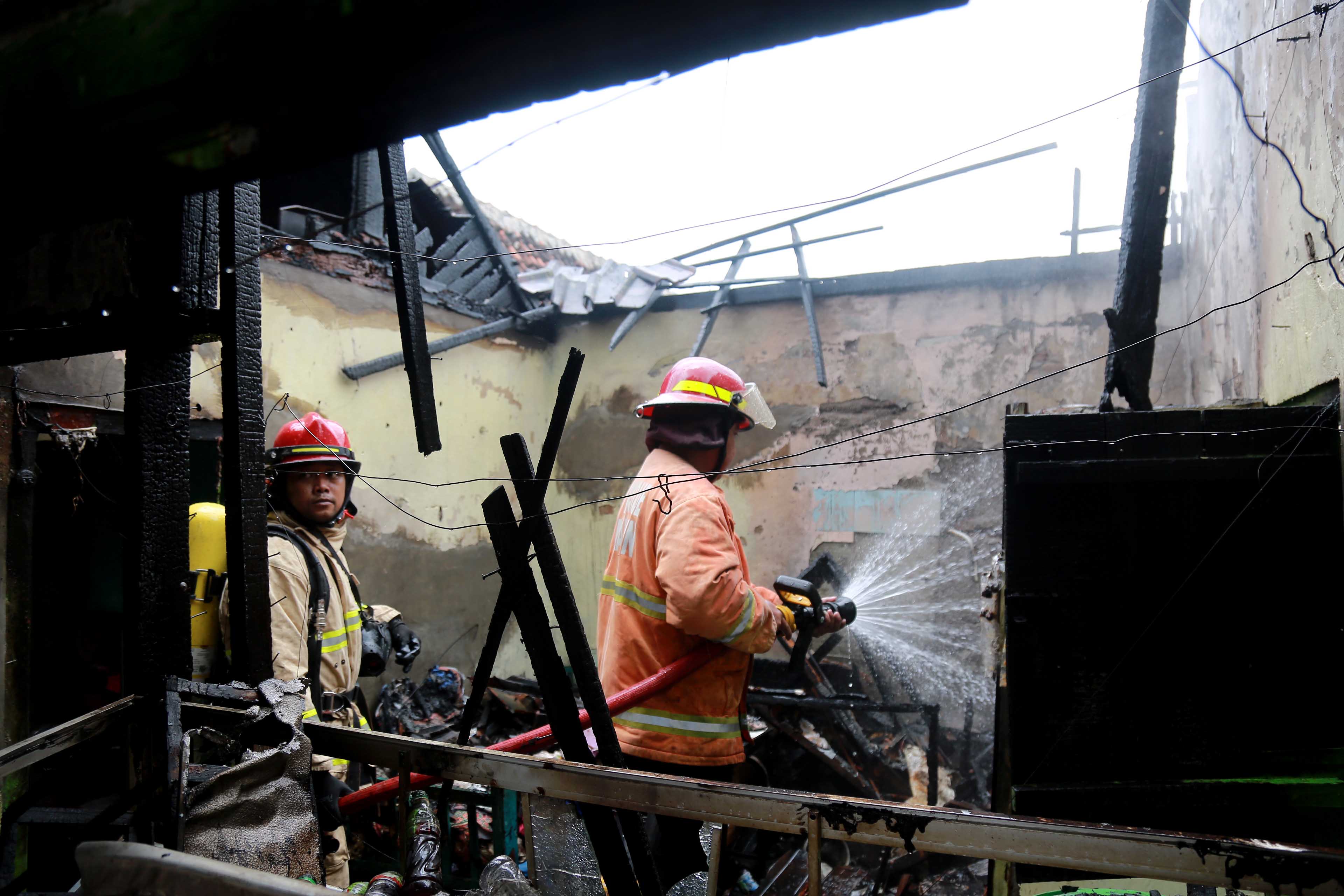 PENDINGINAN: Petugas damkar memadamkan api yang menghanguskan dapur dan toko kelontong milik Siman di Jalan Gajah Mada, Senin 17 Februari 2025.