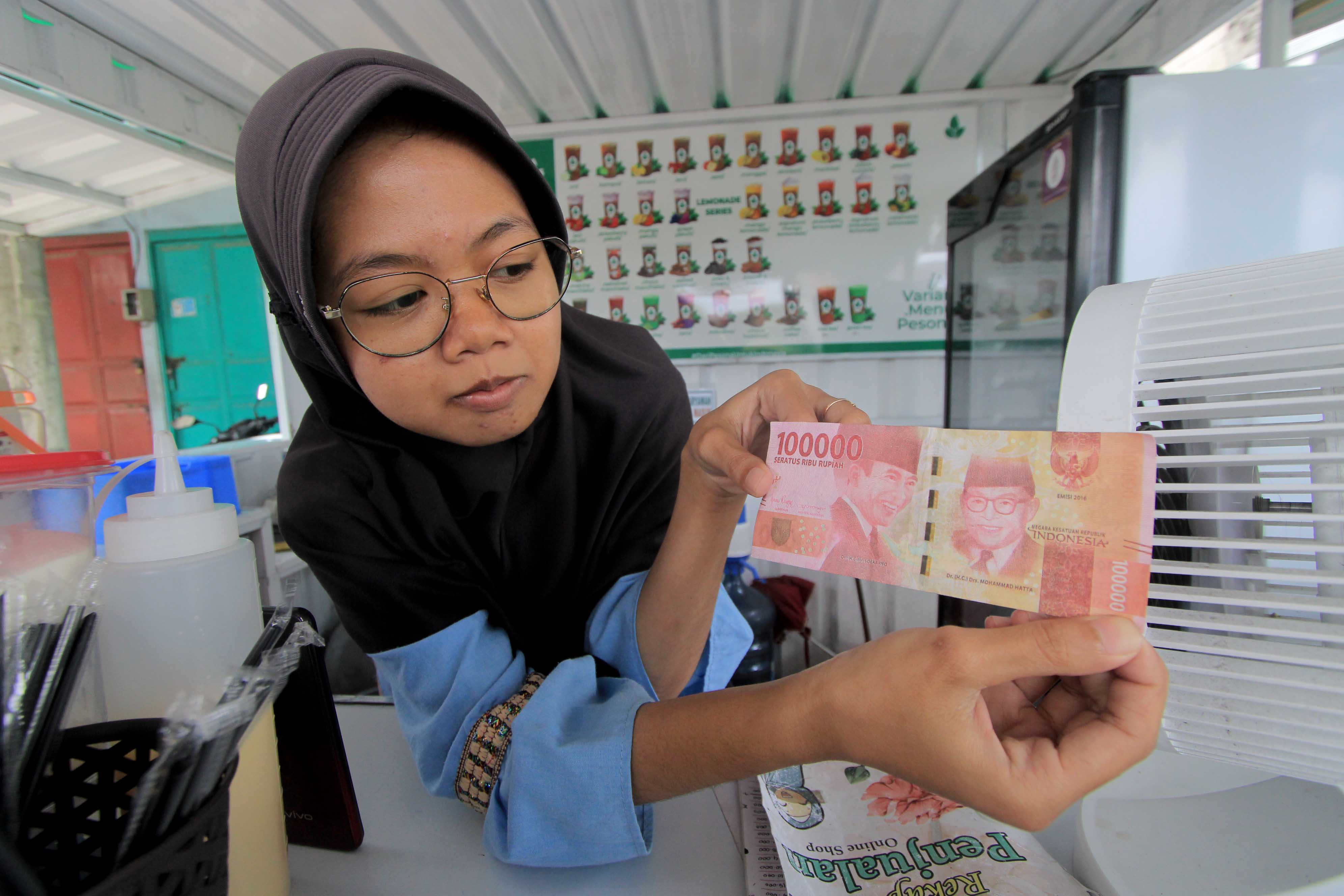 TIRUAN: Nilhal Muna Assofiyah menunjukkan uang palsu yang diterimanya dari pembeli, Rabu 19 Februari 2025.&nbsp;