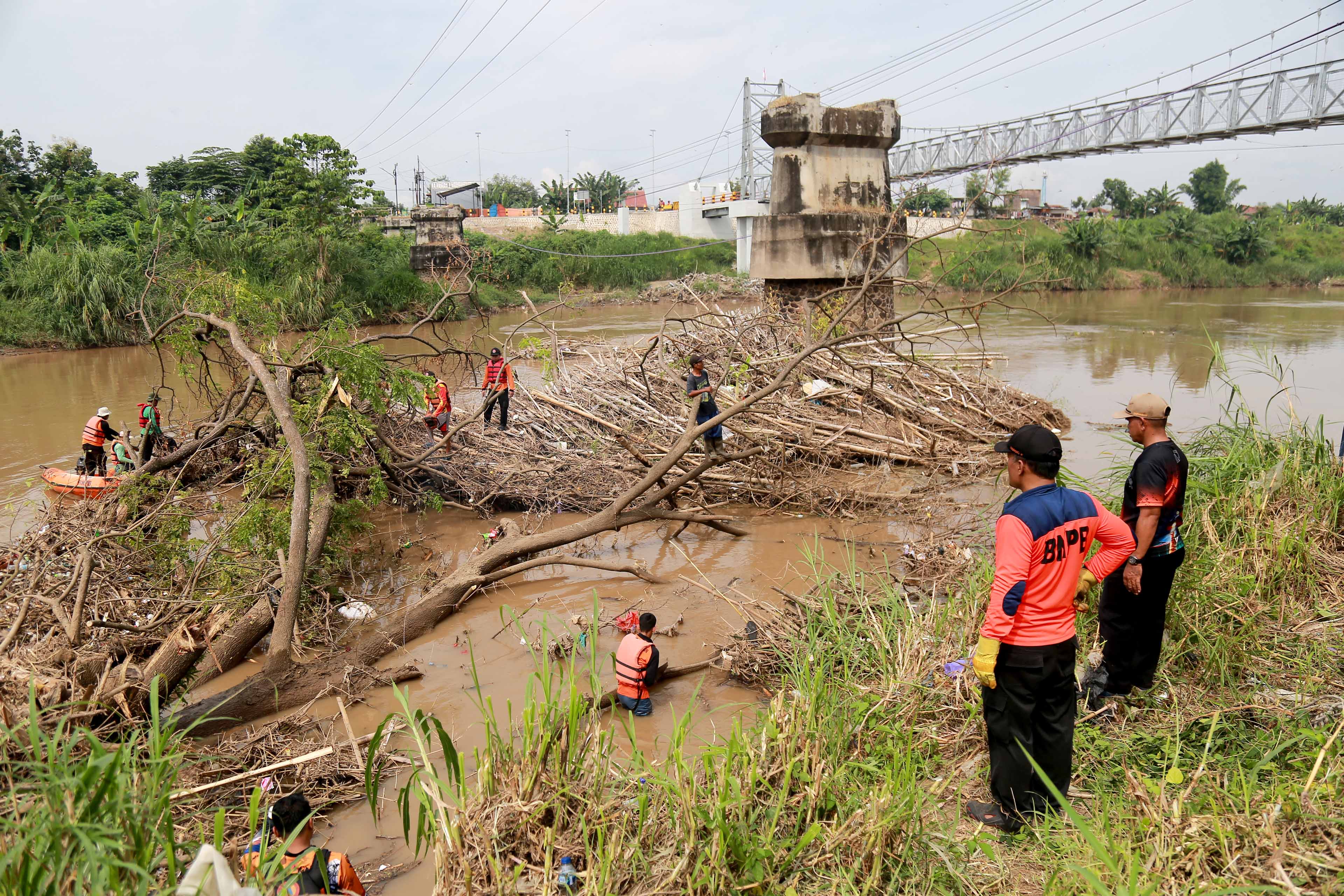 PEMBERSIHAN: Sejumlah petugas membersihkan sampah di pancang bekas Jembatan Patihan.