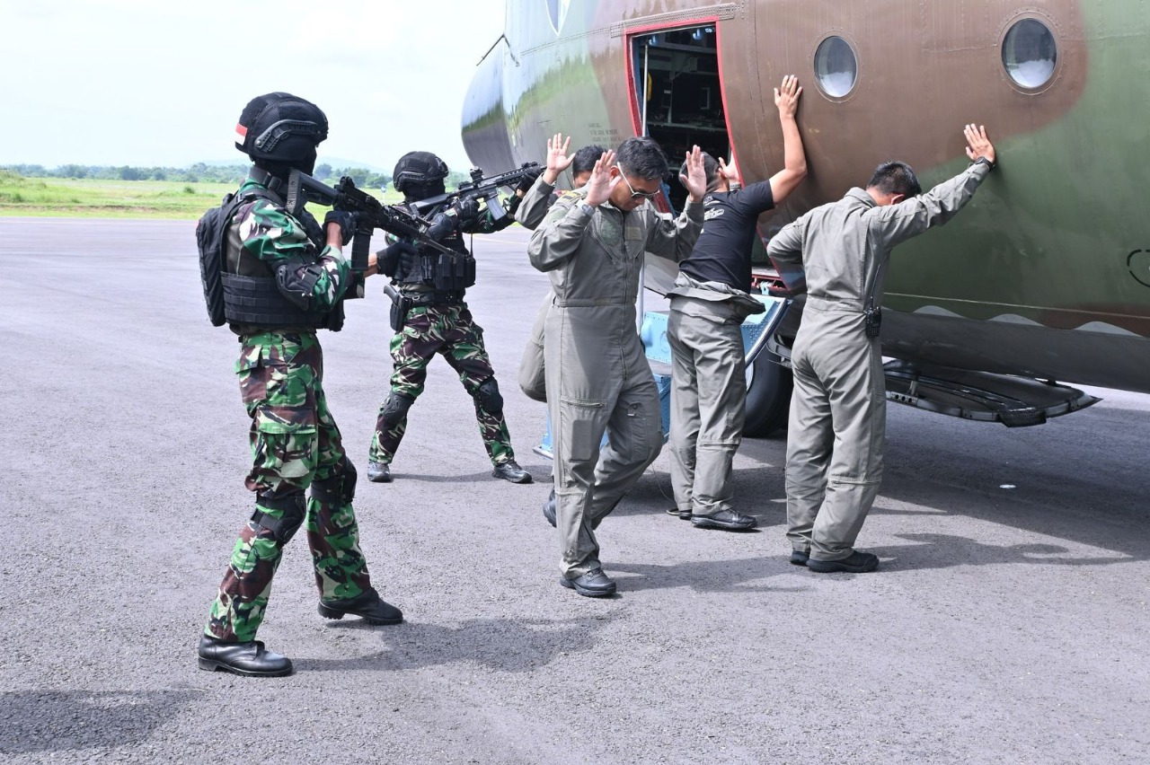 SIMULASI: Pesawat Hercules asing dipaksa mendarat di Lanud Iswahjudi. Foto insert, TNI AU dengan sigap menetralkan personel yang mendarat darurat.