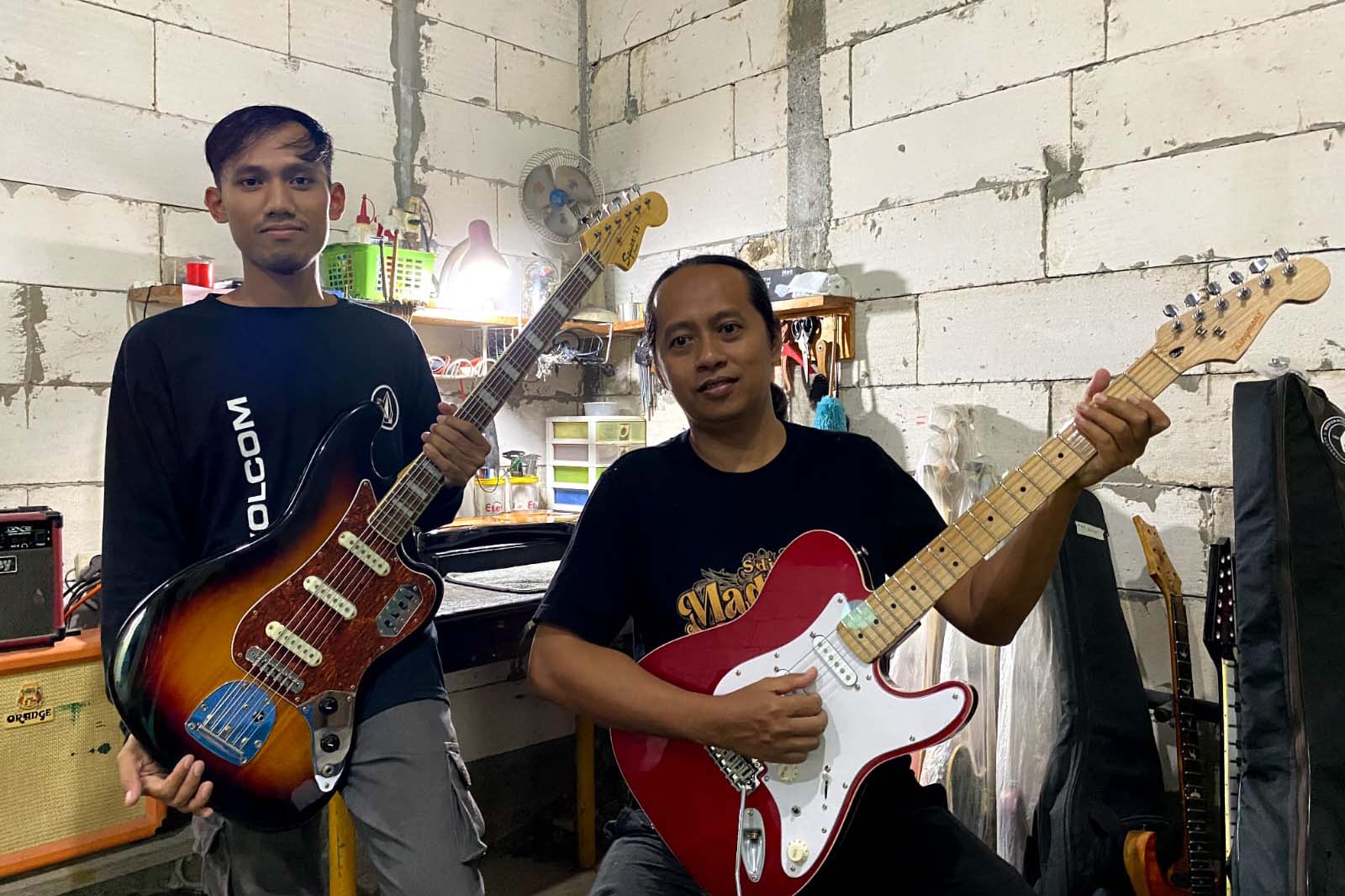 LUTHIER: Jujuk Joko Sulistyo (rambut panjang) dan Anas menunjukkan beberapa produk gitar buatannya yang berada di Desa Tempursari, Kecamatan Wungu.