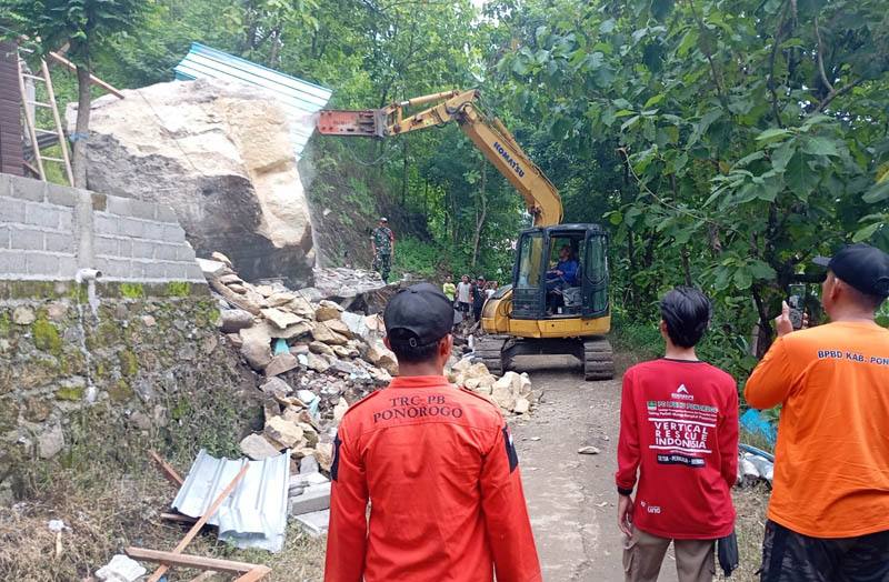 DIHANCURKAN: BPBD Ponorogo mengirimkan alat berat untuk mengevakuasi material batu berukuran jumbo yang menghancurkan rumah Narto di Desa Ngilo-ilo, Slahung.