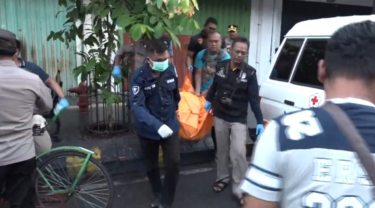 Polisi mengevakuasi jasad pengayuh becak yang meninggal di trotoar jalan Kota Madiun, Rabu (26/2).