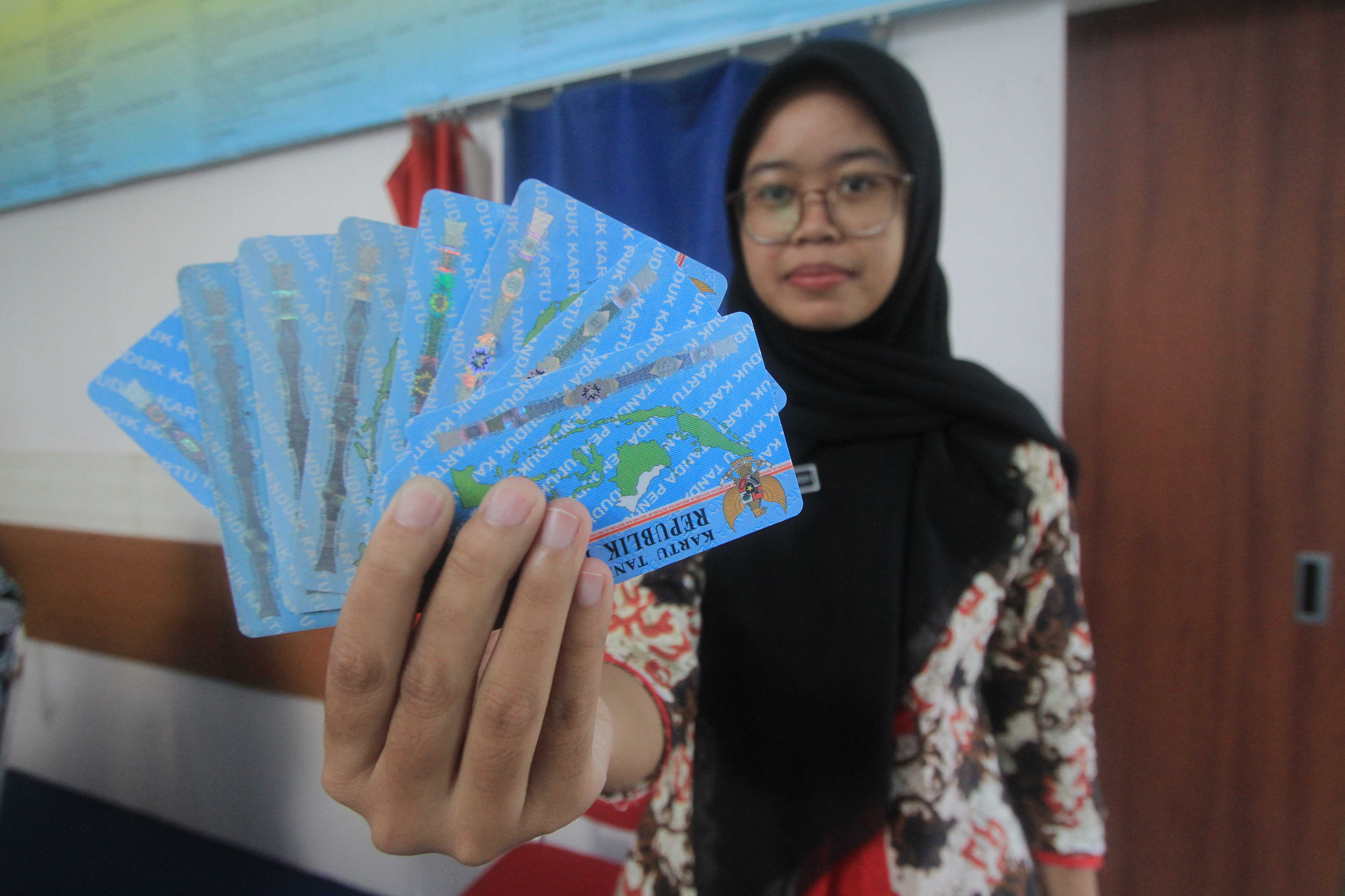 IDENTITAS DIRI: Petugas Disdukcapil Magetan menunjukkan e-KTP milik warga Magetan yang sudah selesai dicetak.