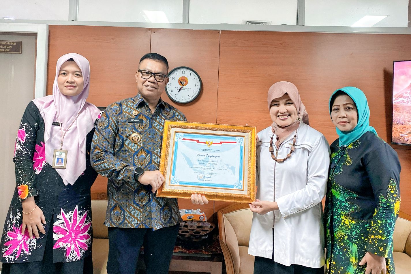 BERGENGSI: Pj Bupati Nizhamul (dua dari kiri) didampingi Kepala DPMPTSP Magetan Sunarti Condrowati (kanan) saat menerima penghargaan pelayanan prima dari Kementerian PANRB.