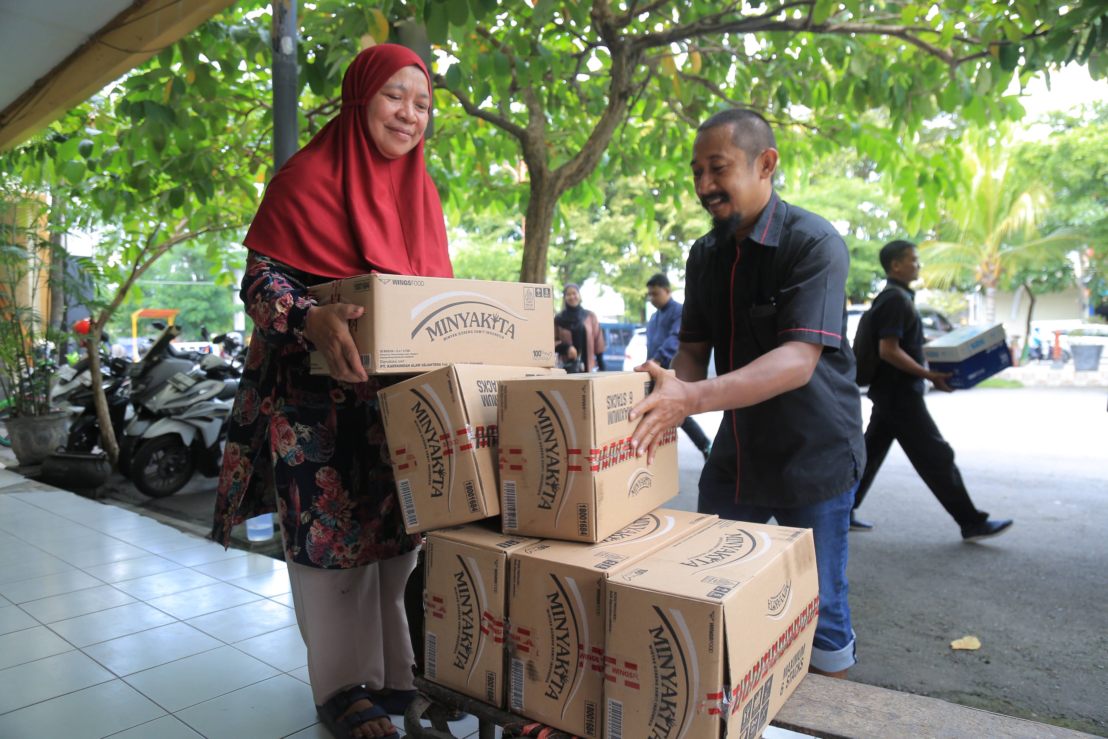 BAHAN POKOK: Para pedagang antre beli Minyakita di Pasar Besar Madiun (PBM), Selasa 11 Maret 2025.
