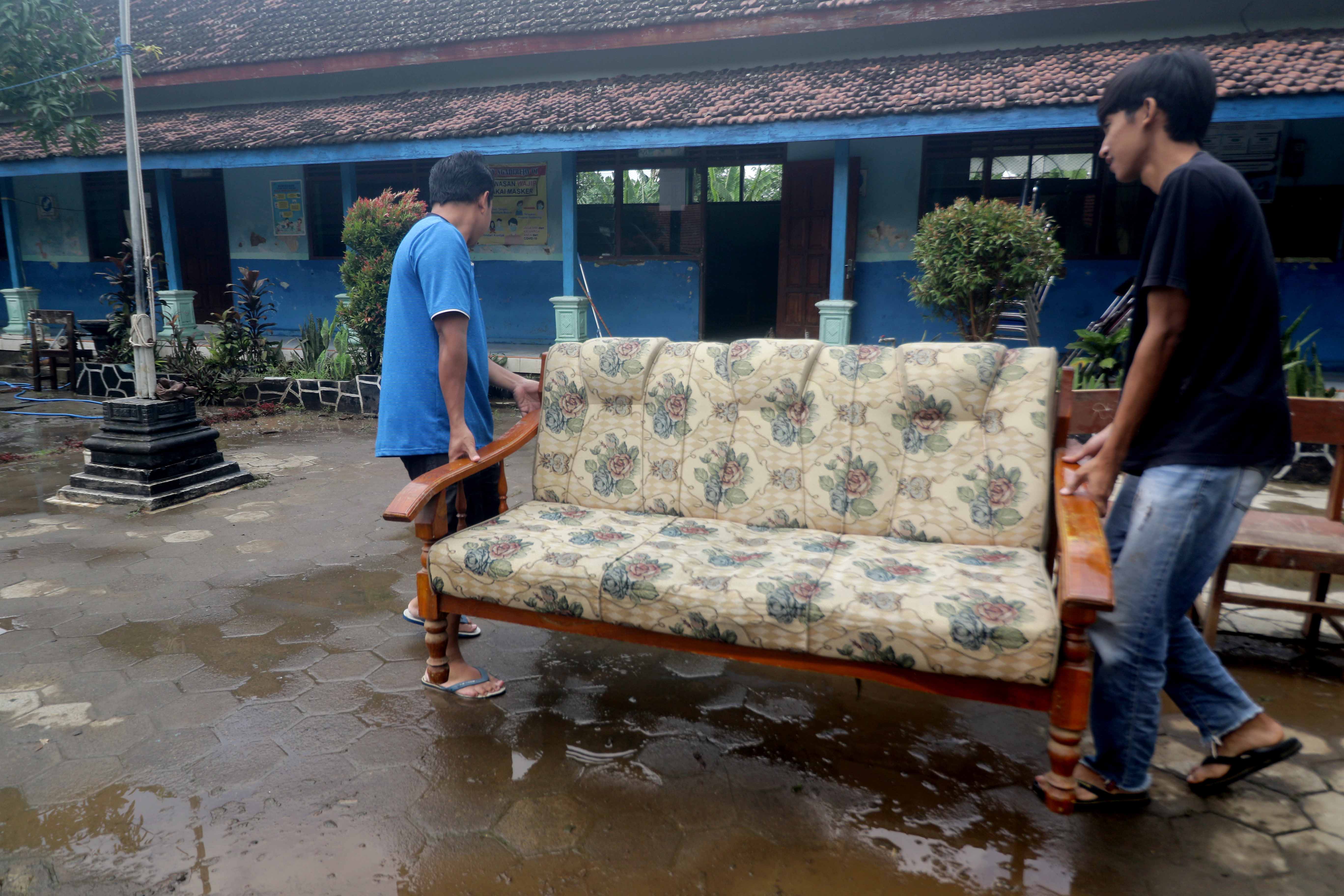 KERJA BAKTI: Wali murid bersama guru kerja bakti membersihkan banjir yang merendam SDN Ngadirejo 01 pada Sabtu 15 Maret 2025 lalu.