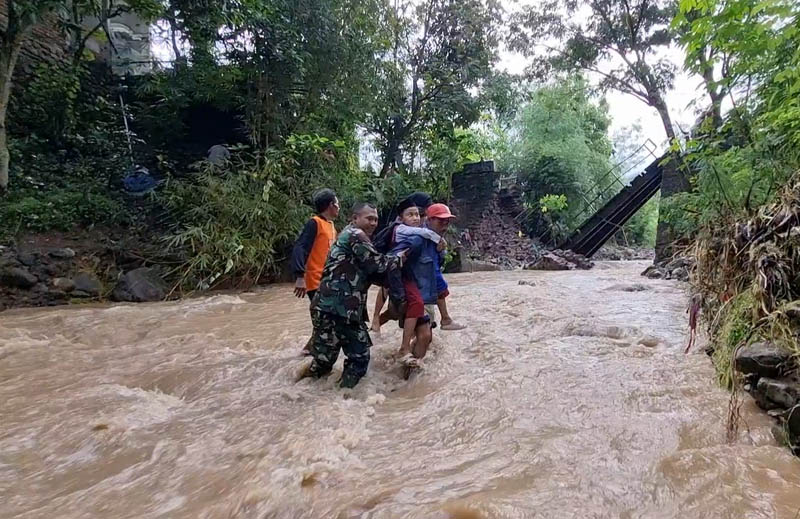TERDAMPAK BANJIR : Dua jembatan di Dusun Sumberejo, Desa Munggu, Kecamatan Bungkal, Ponorogo, dilaporkan rusak terdampak banjir. Warga nekat terjang derasnya arus sungai, Selasa 18 Maret 2025.