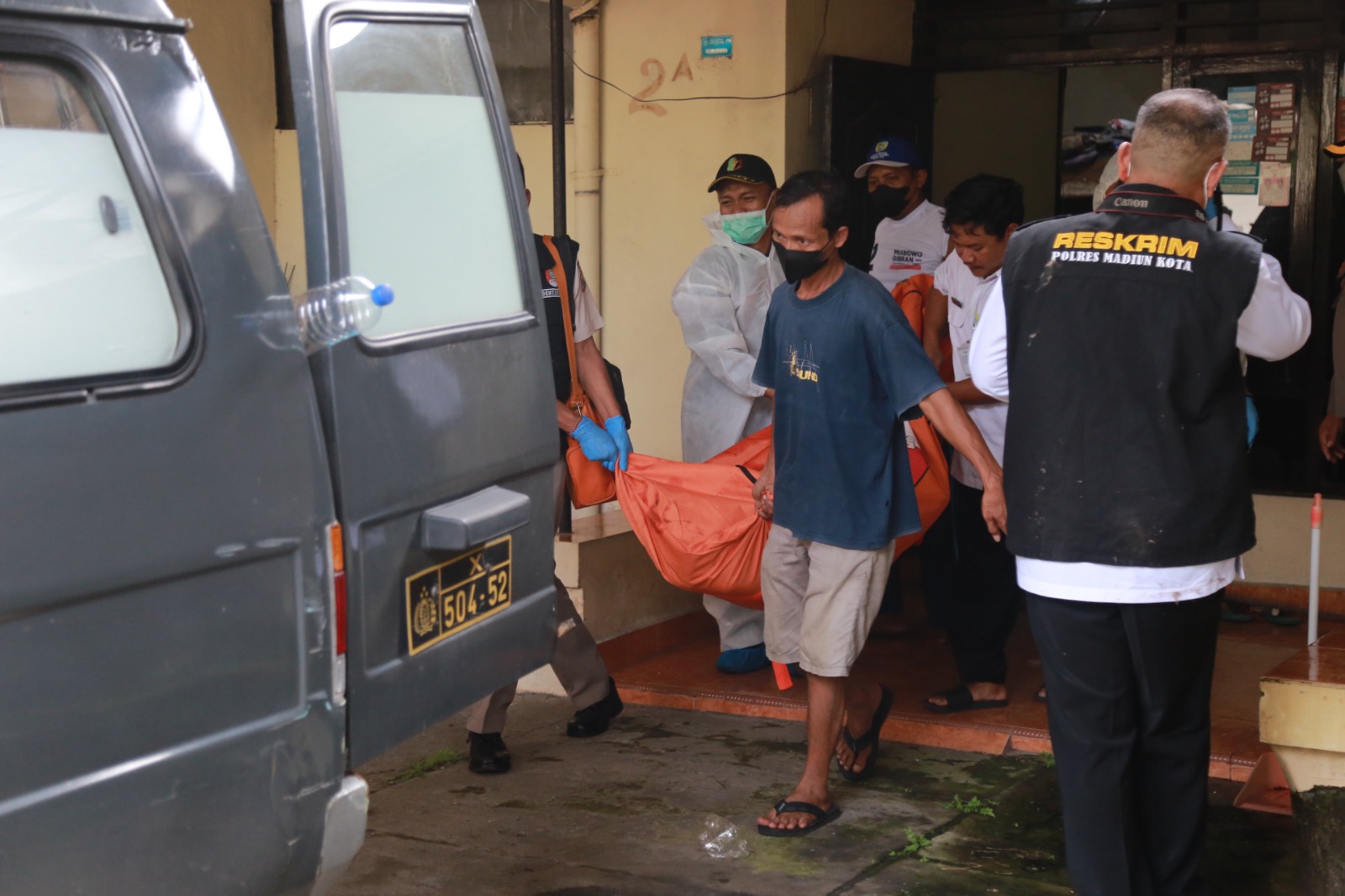 Polisi mengevakuasi jasad Titik yang telah meninggal dunia di dalam rumahnya di Jalan Pilang Madya, Rabu (19/3). FOTO: BAGAS BIMANTARA/RADAR MADIUN