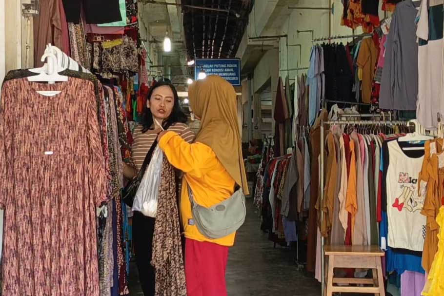 MENGGELIAT: Pedagang pakaian di Pasar Minulyo Pacitan mulai tersenyum lega karena jumlah pembeli kebutuhan Lebaran cenderung meningkat sejak awal Ramadan lalu.