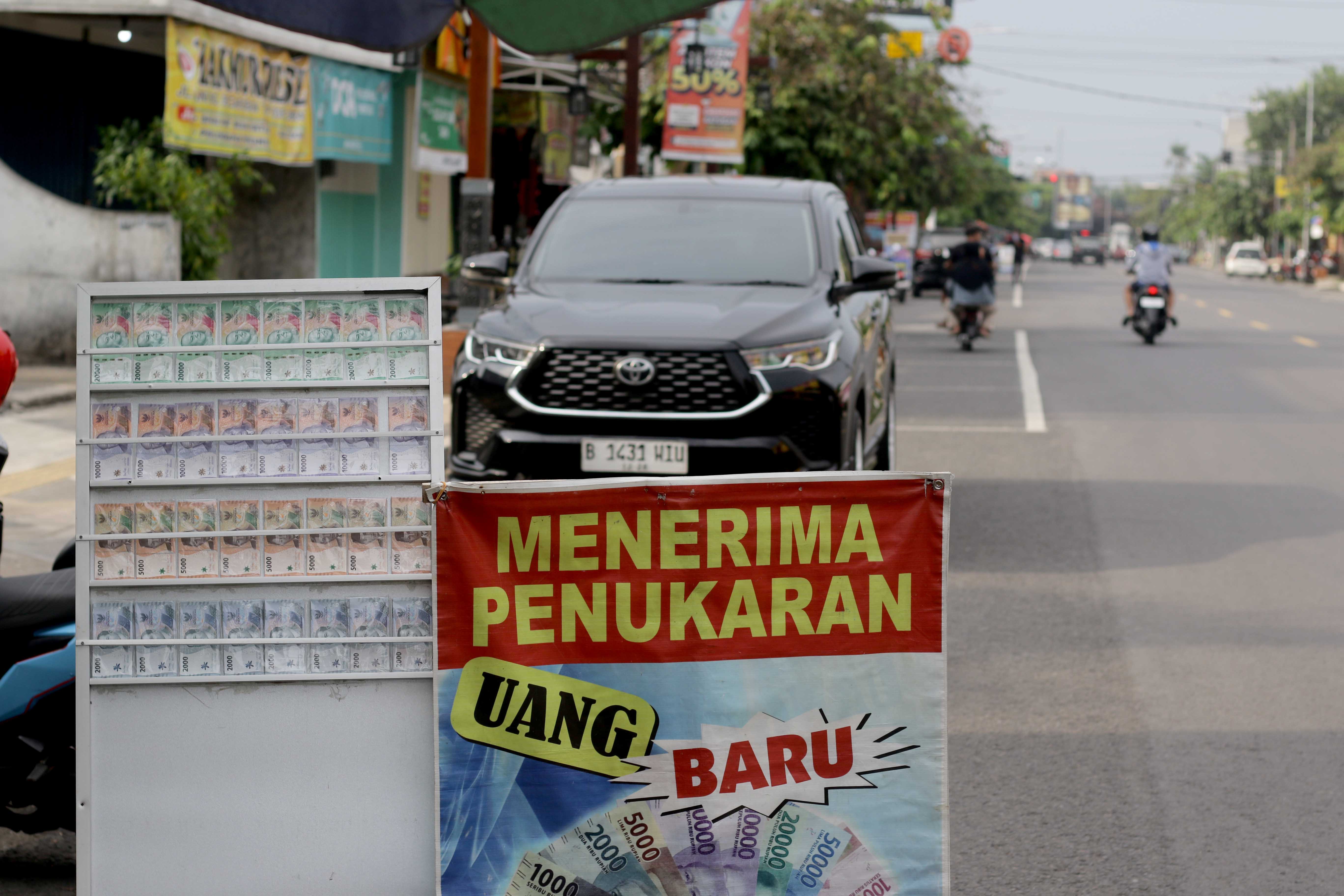SETIA: Jasa tukar uang baru dipinggir Jalan Ahmad Yani, Caruban masih sepi peminat.  