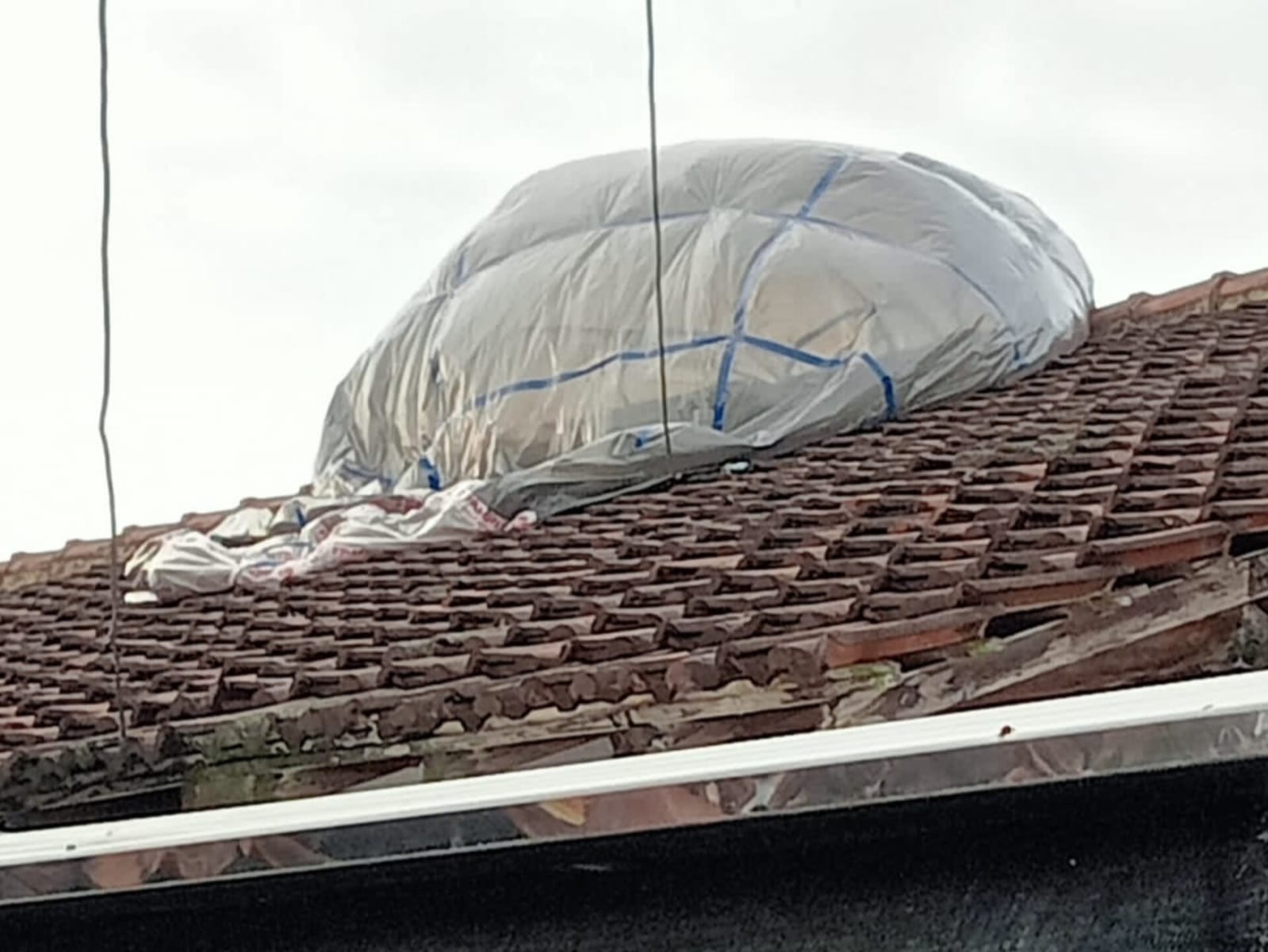 Balon udara tanpa awak tersangkut di atap rumah warga yang berada di Jalan Margobawero, Kota Madiun, Minggu (6/4). FOTO: ISTIMEWA