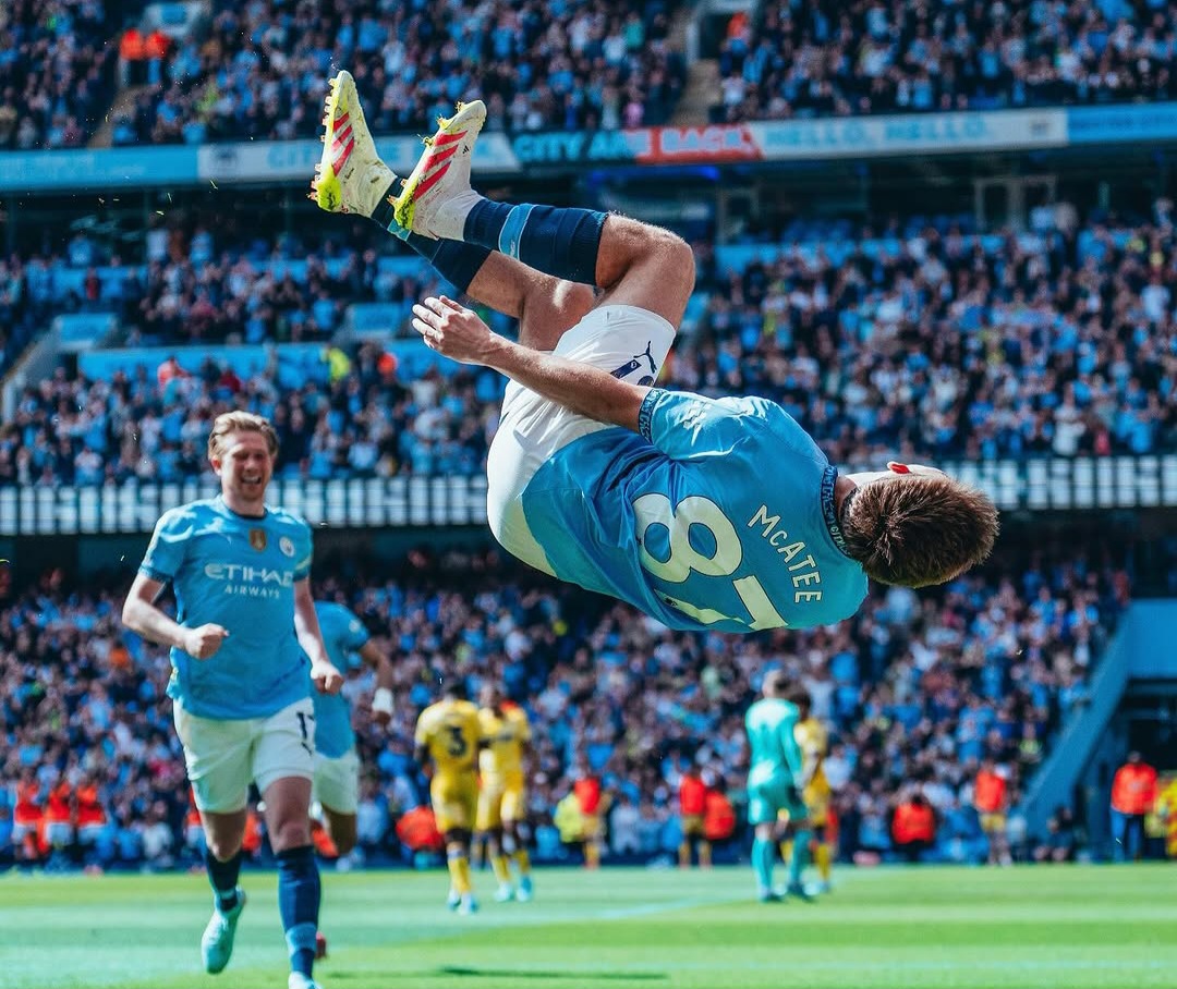 James McAtee, pemain Man City merayakan gol dengan selebrasi akrobatik.