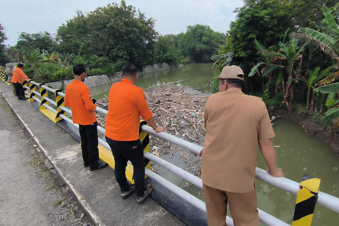 Kalaksa BPBD Kabupaten Madiun Bobby Saktia Lubis bersama personel dan pemdes setempat memeriksa tumpukan sampah Jembatan Kedungbanteng, kemarin (14/4). FOTO:&nbsp;BPBD KABUPATEN MADIUN FOR RADAR CARUBAN