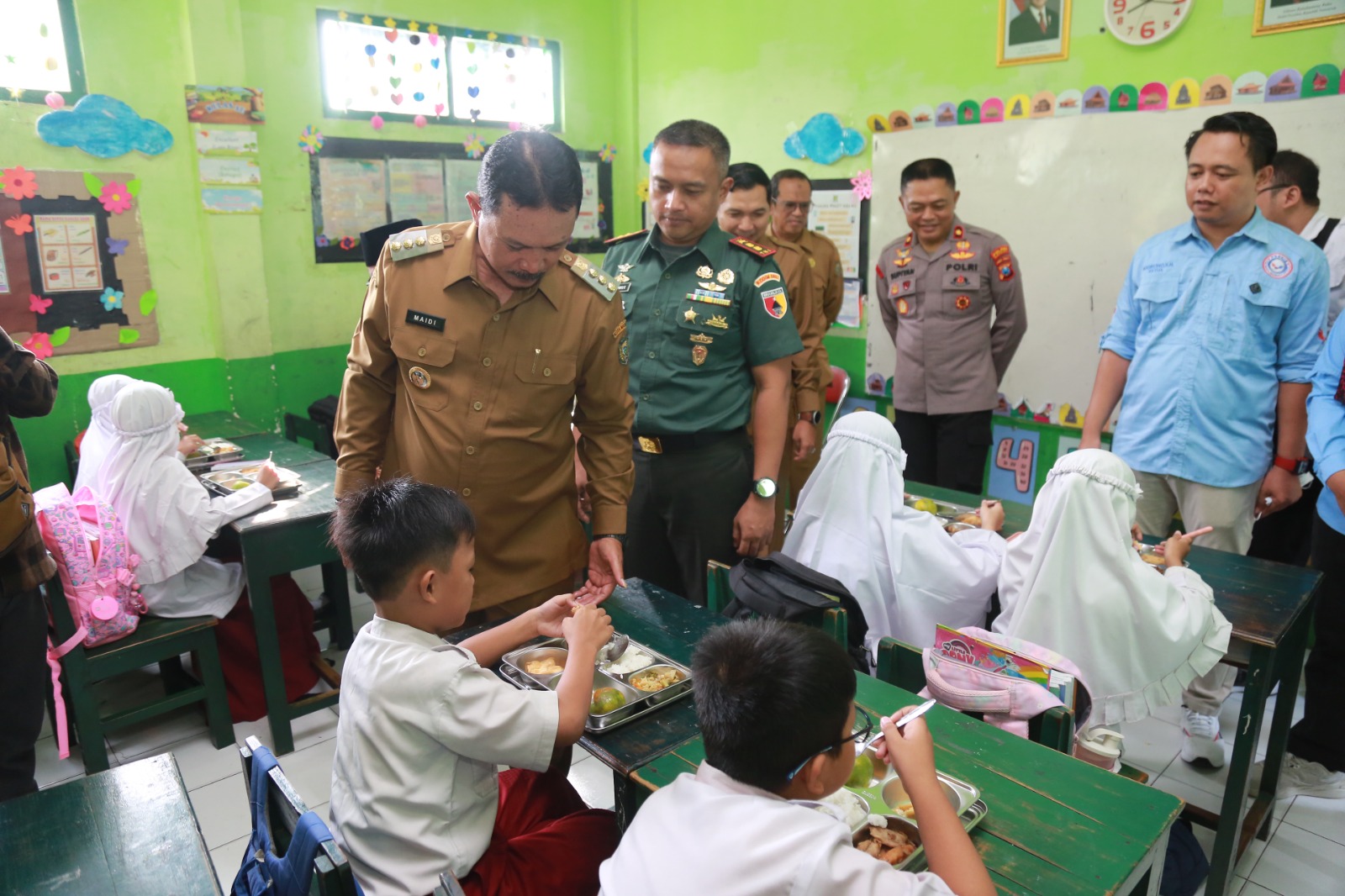 Wali Kota Madiun Maidi memberikan suapan nasi kepada siswa penerima program MBG di MIT Bakti Ibu,&nbsp;Senin (14/4).&nbsp;FOTO: BAGAS BIMANTARA/JAWA POS RADAR MADIUN