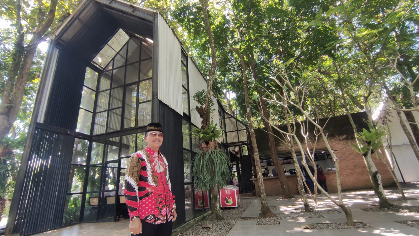 Kepala Desa Brubuh Muhtarom di depan Kayangan Cafe and Space
