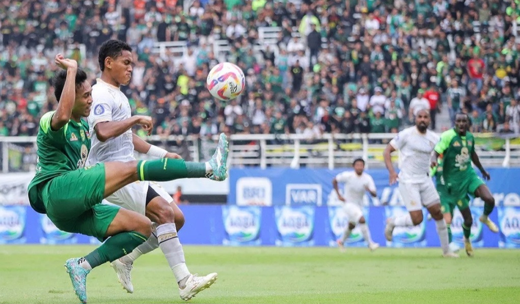 Arief Catur Pamungkas (kiri) menendang bola dengan dihadang  Muhammad Iksan Lestaluhu (kedua kiri) pada pertandingan BRI Liga 1 di Stadion Gelora Bung Tomo, Surabaya, Jawa Timur, Sabtu (7/12/2024).