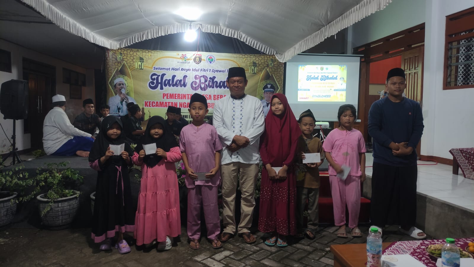 SANTUNAN: Kades menyerahkan santunan kepada sejumlah anak sebelum mengawali kegiatan halal bihalal.