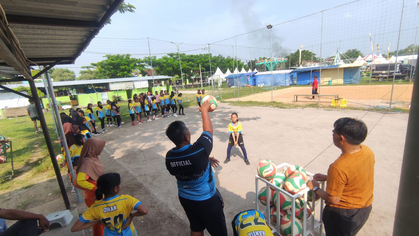LATIHAN: Pelatih memberikan latihan teknik dasar voli ke pada anak-anak.
