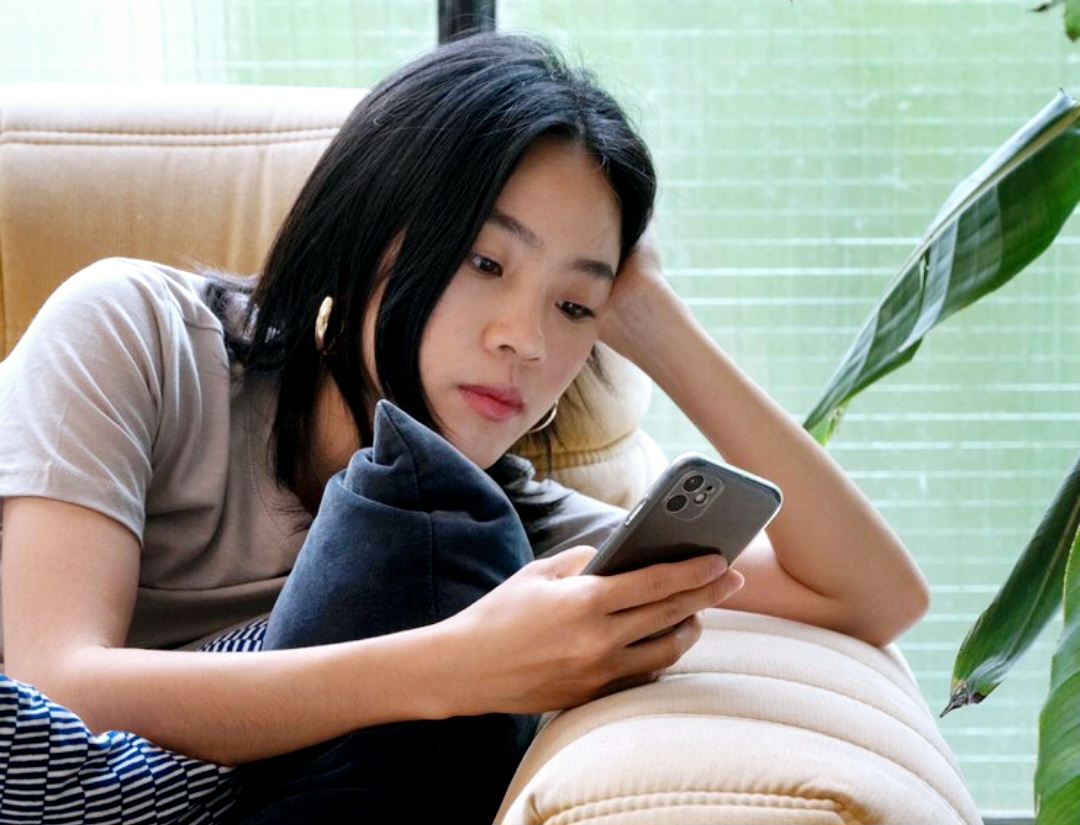 Ilustrasi perempuan sedang scrolling media sosial.