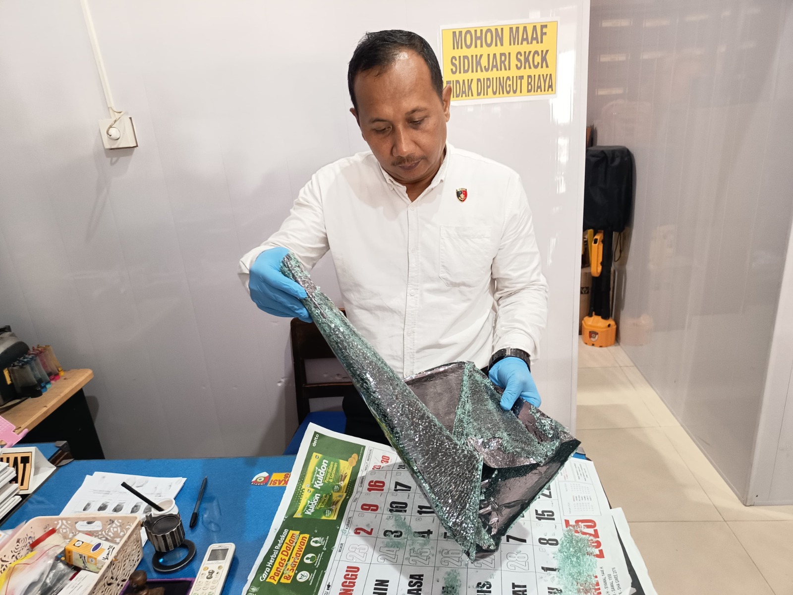 Polisi menunjukkan pecahan kaca mobil Pajero milik korban yang dipecah oleh pelaku, Selasa (6/5). FOTO: SUGENG DWI N/RADAR PONOROGO