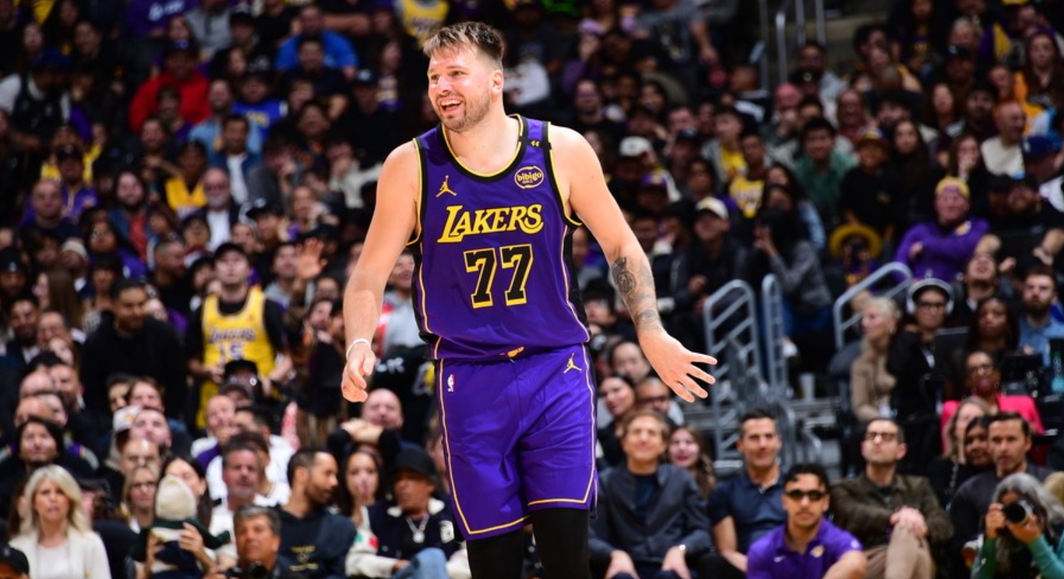 Luka Doncic mengenakan seragam LA Lakers ungu bernomor 77.