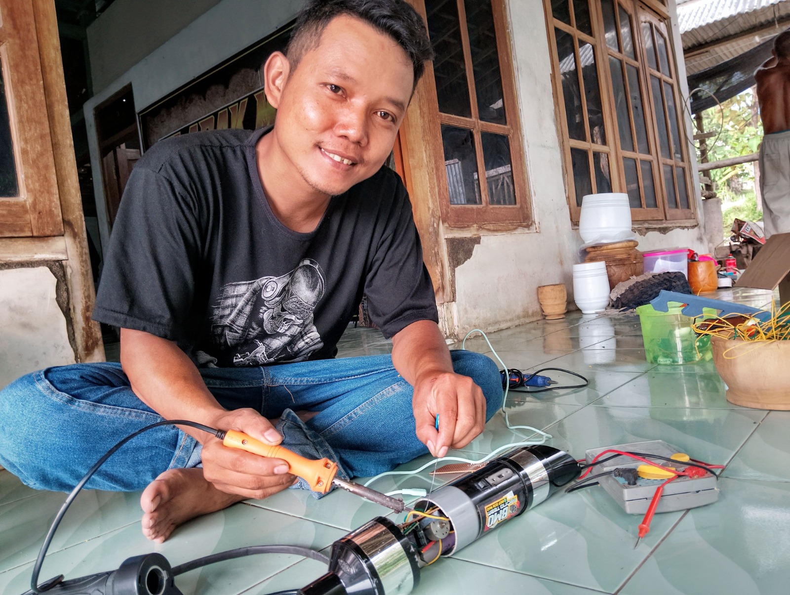 Budi Santoso sedang merakit knalpot racing elektronik buatannya yang laris hingga ke luar Jawa. FOTO: LODITYA FERNANDES/RADAR MADIUN