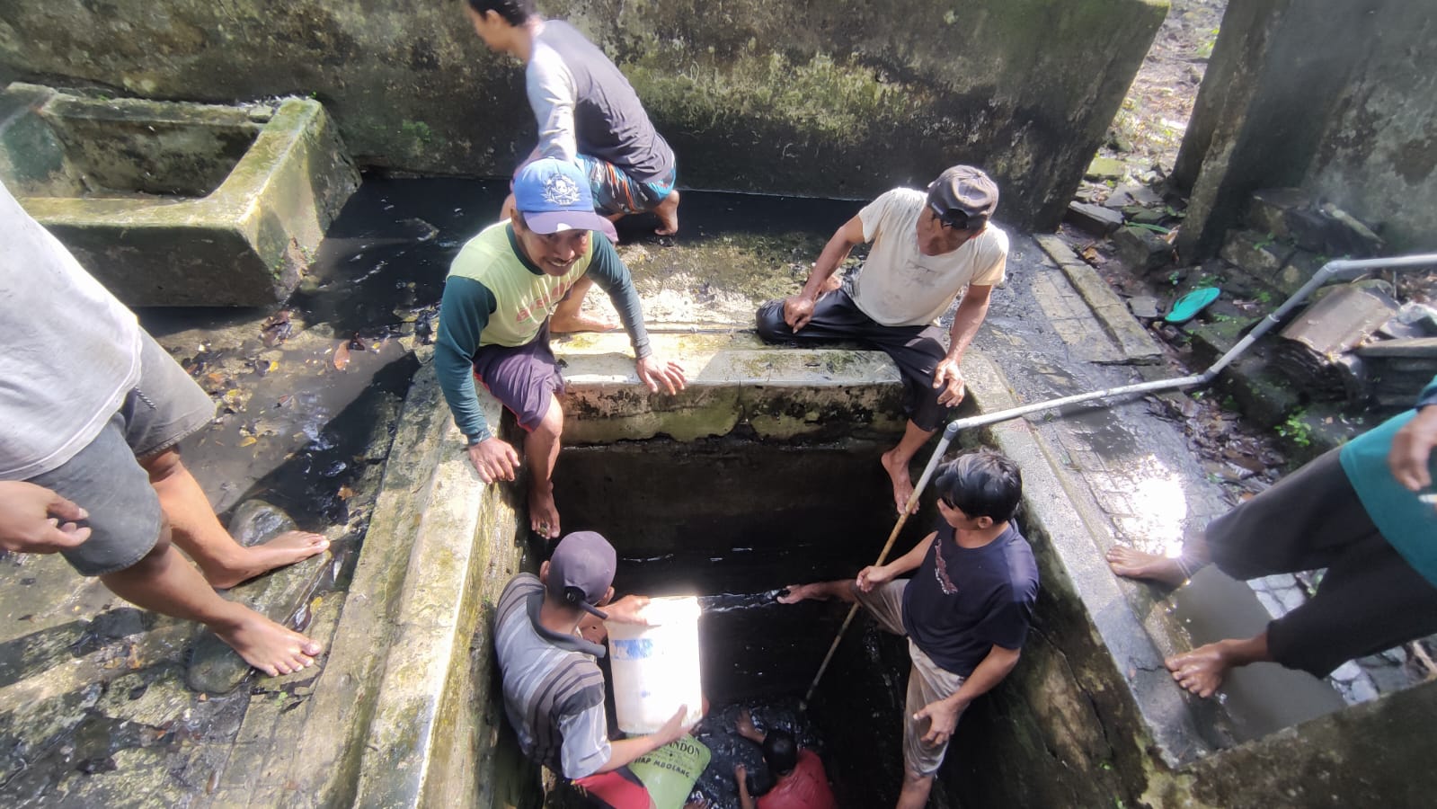 KURAS SUMUR: Sejumlah warga Banyuurip melaksanakan Nyadran sekaligus bersih-bersih lingkungan sekitar dan menguras sendang.