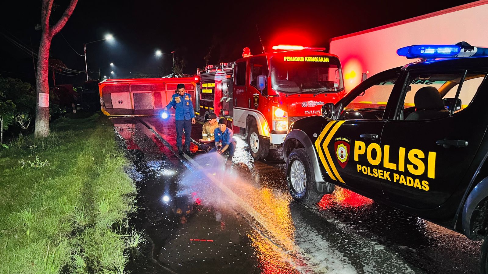 Petugas damkar membersihkan tumpahan gula cair di Jalan Raya Ngawi&ndash;Karangjati. FOTO: DAMKAR NGAWI