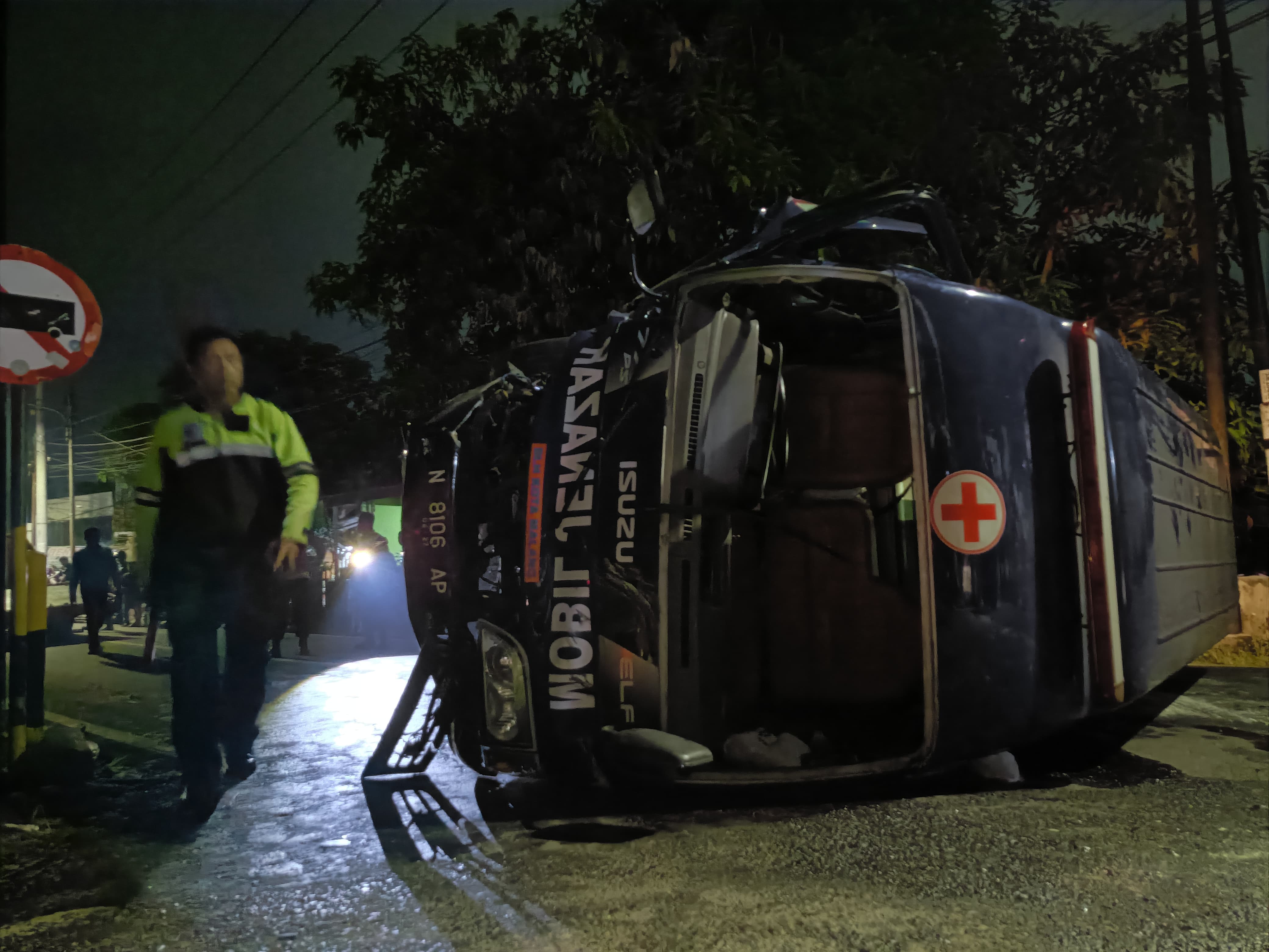 Mobil ambulans jenazah terguling di Jalan S Parman, Kota Madiun. Mobil celaka dalam perjalanan menuju Geger, Madiun saat mengantarkan jenazah. FOTO: BAGAS BIMANTARA/RADAR MADIUN
