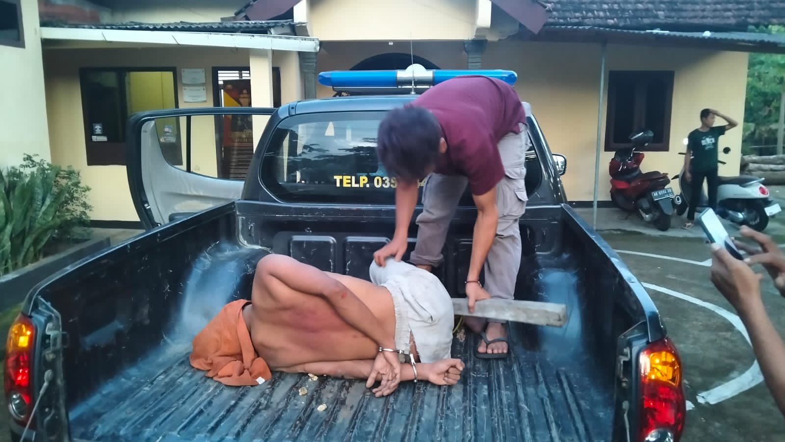 Polisi mengamankan Slamet yang mengamuk dan membacok 7 warga di Ngadirojo, Pacitan. FOTO: NUR CAHYONO/RADAR PACITAN